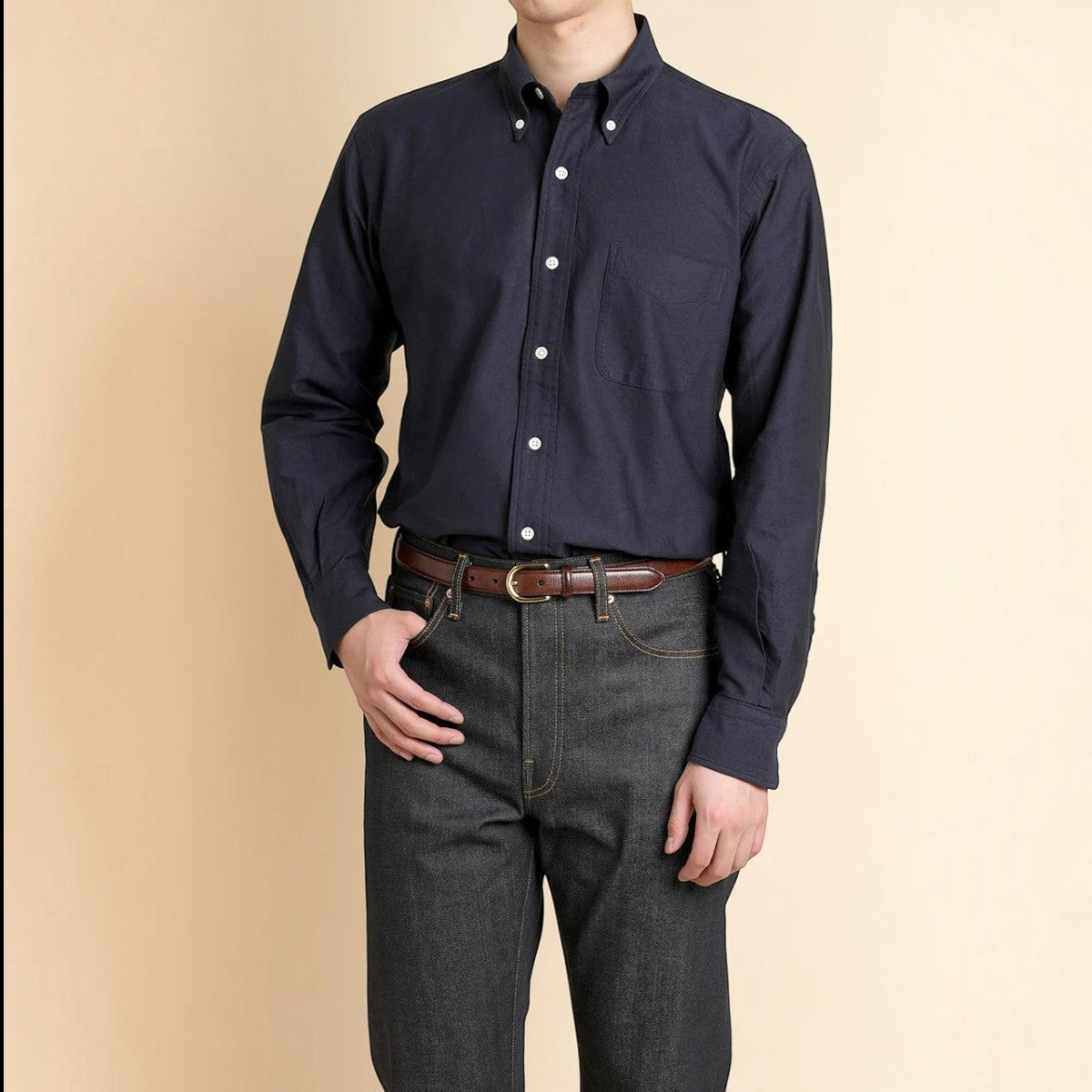 Kamakuran avy blue cotton oxford button-down shirt with chest pocket and cream shell buttons on a model.