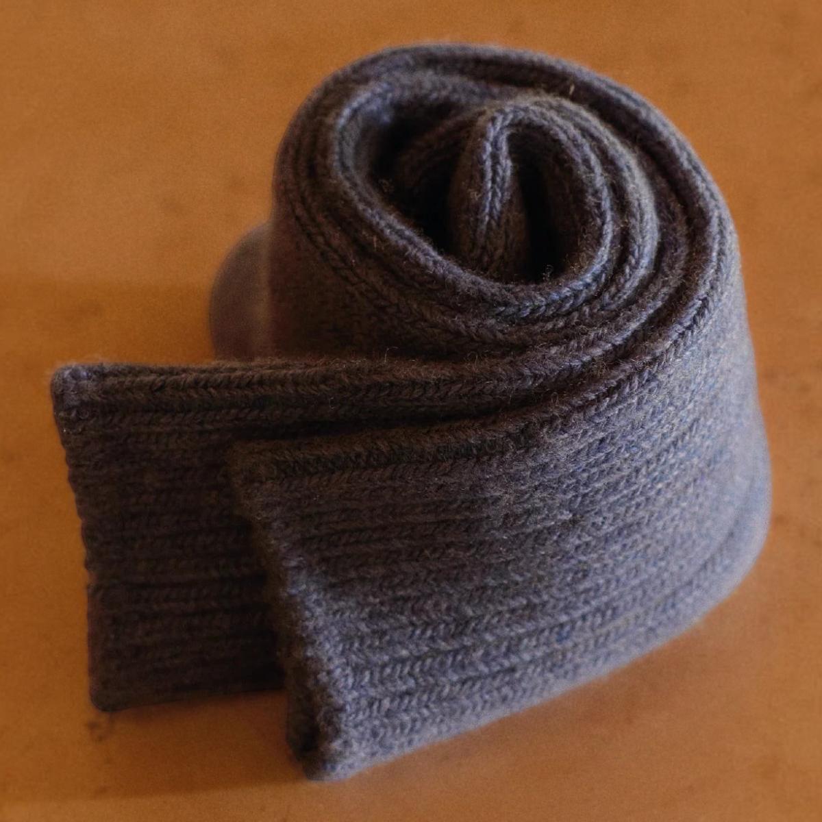 MILWORKS blue ribbed wool and cashmere blend socks rolled up on a smooth surface