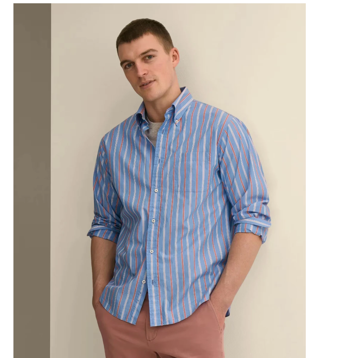 MILWORK blue cardinal stripe cotton poplin button-down shirt worn by a man with pink pants. Features a classic collar and barrel cuffs.