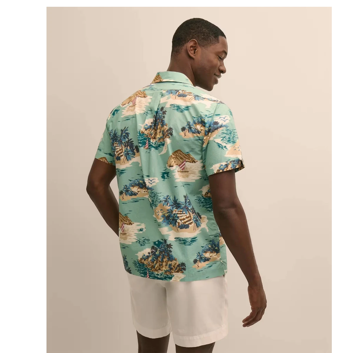 MILWORK blue 100% cotton camp collar shirt with an all-over island motif pattern. Model is 6'0" and wears a size M.