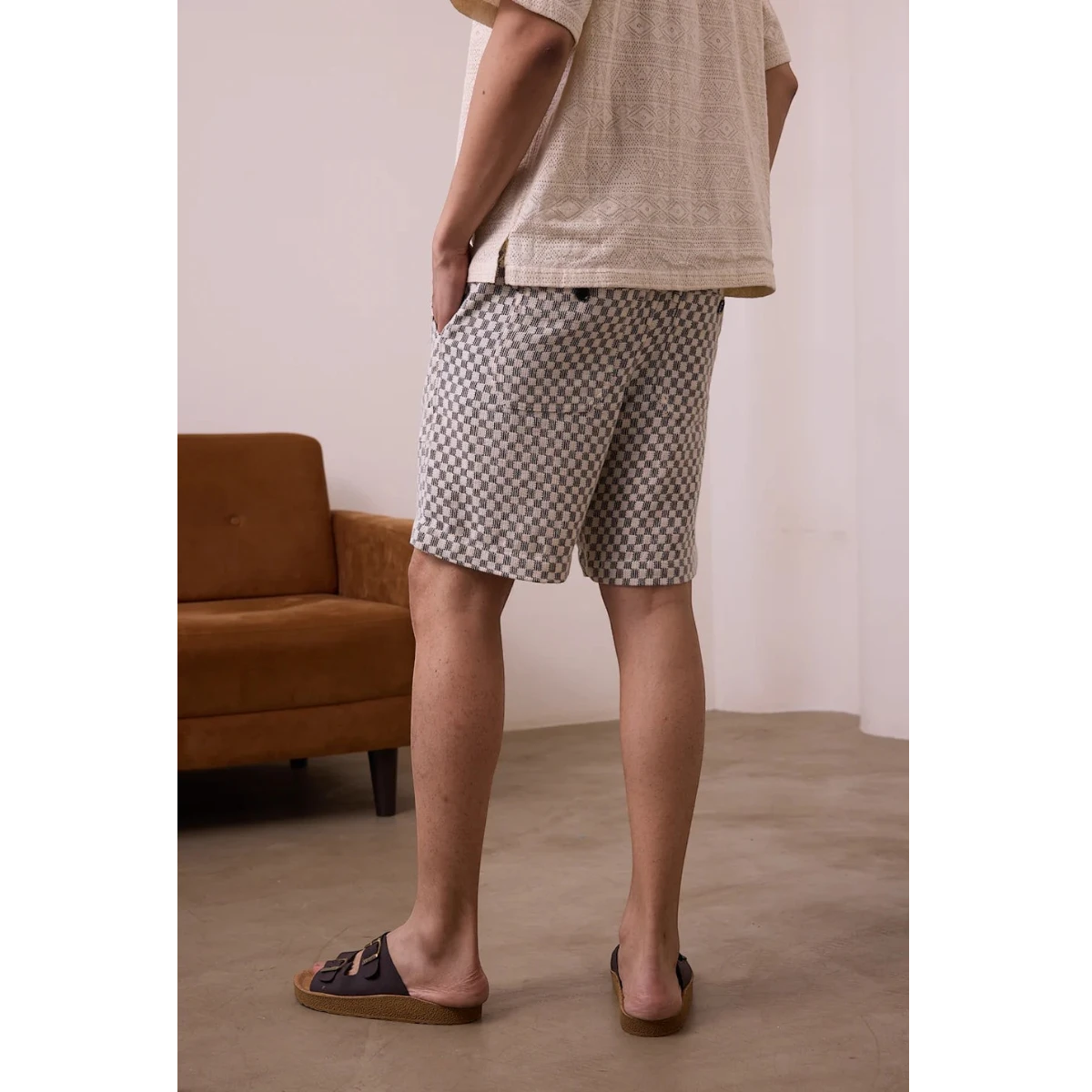 MILWORK Dipak shorts in black and white checkerboard pattern, made from handwoven cotton with an elastic waistband and pockets.
