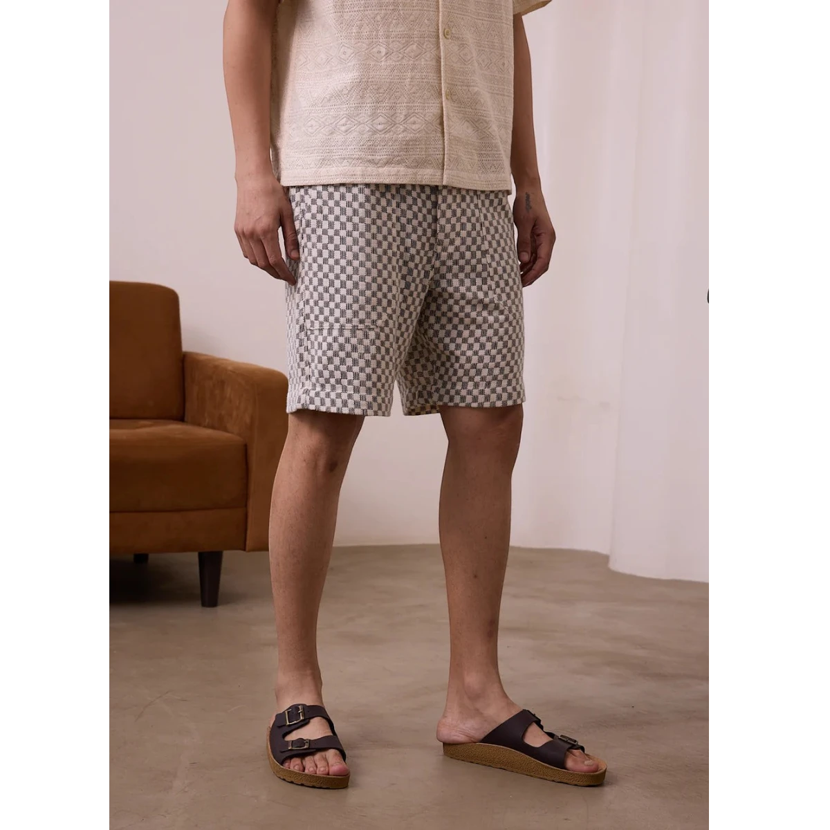 MILWORK Dipak shorts in black and white checkerboard crochet. Relaxed fit, 8" inseam, elastic waistband, and patch pockets.
