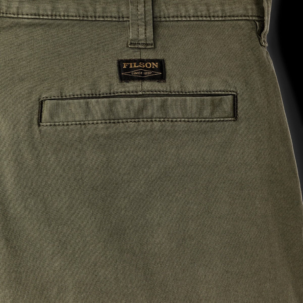MILWORK Granite Mountain 6" shorts in burnt olive, made from cotton-blend fabric with a welted rear pocket and Filson logo tag.