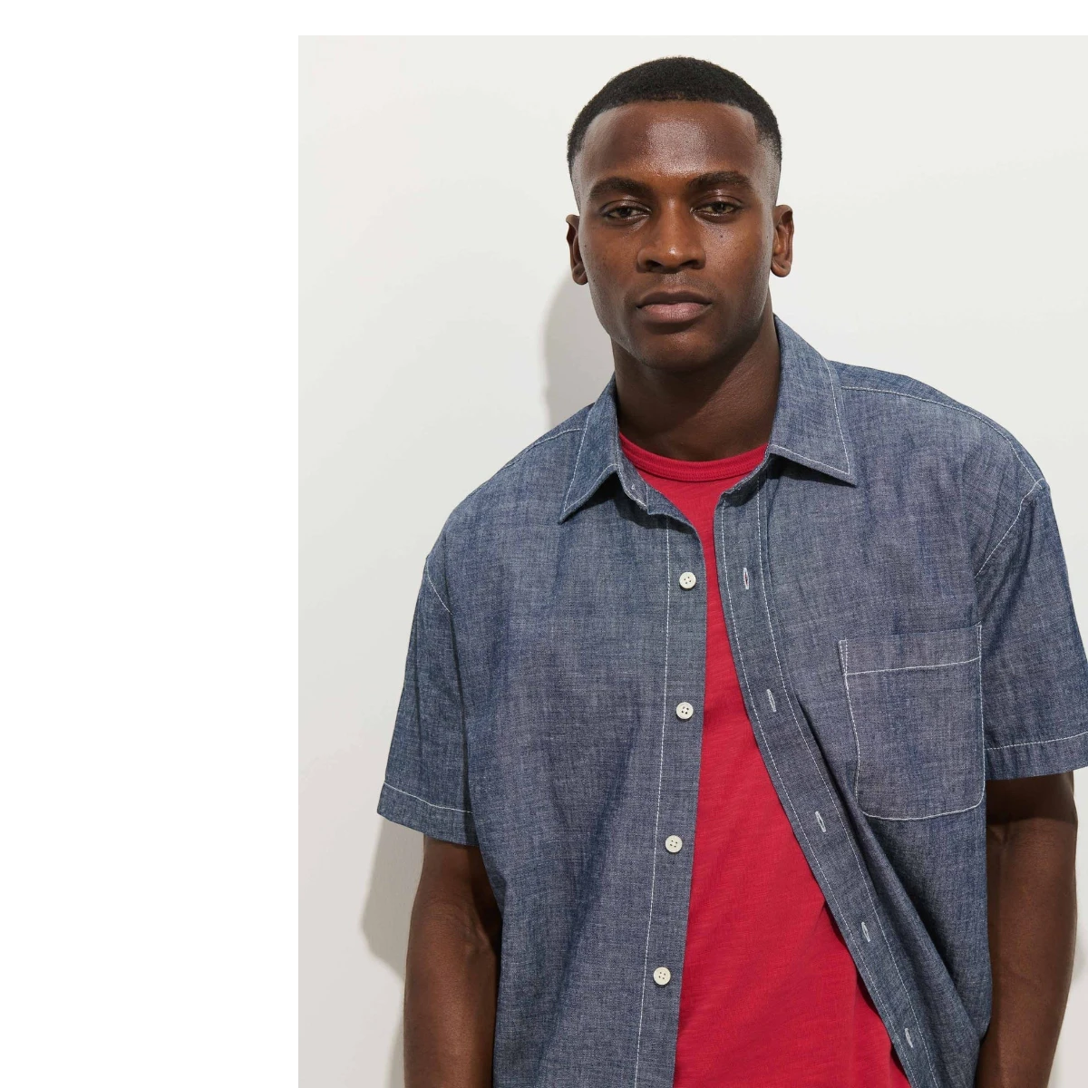 MILWORK Franklin short sleeve indigo chambray shirt with real shell buttons, worn over a red t-shirt.