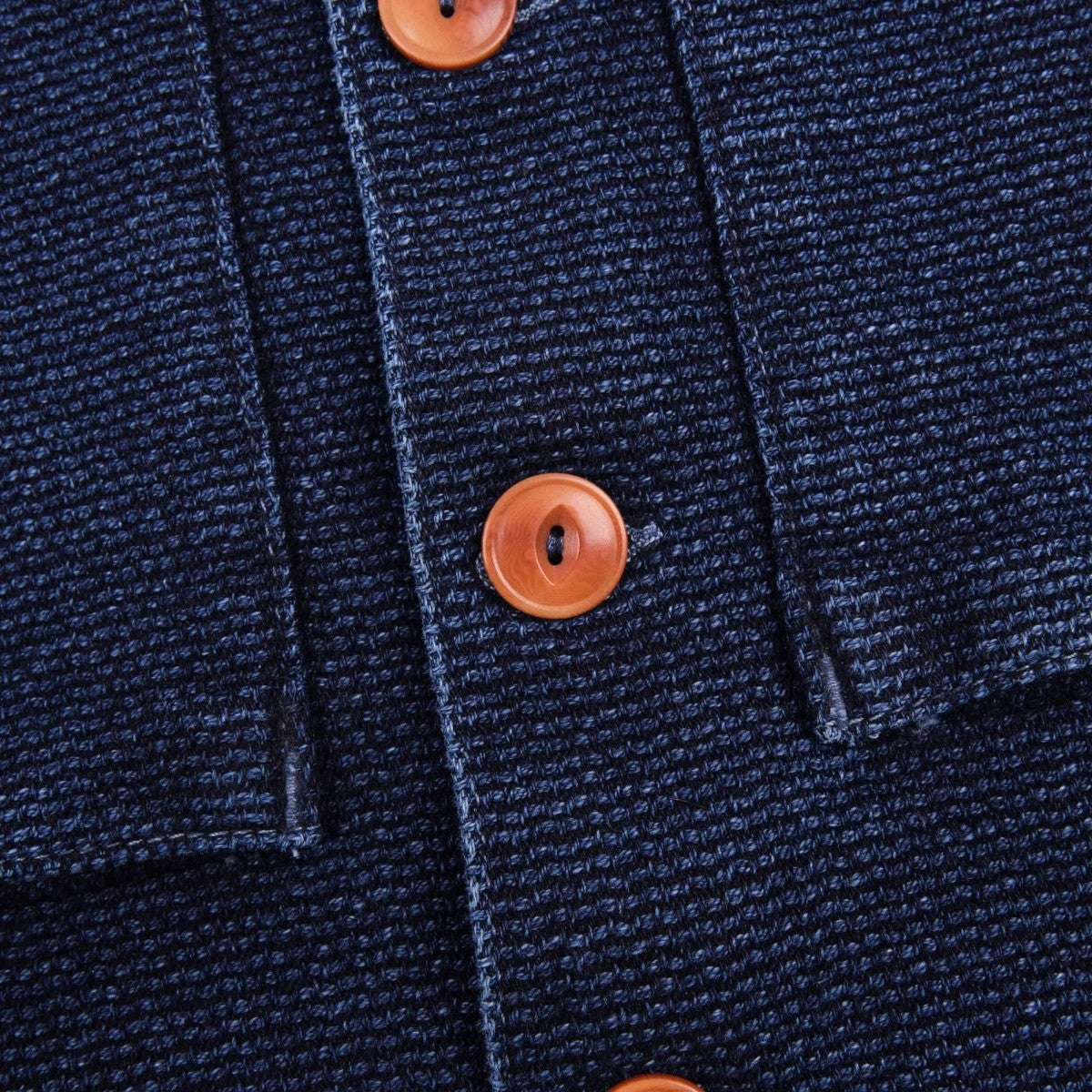 MILWORK Indigo Sashiko shirt with orange corozo buttons and French placket, made from 100% cotton.