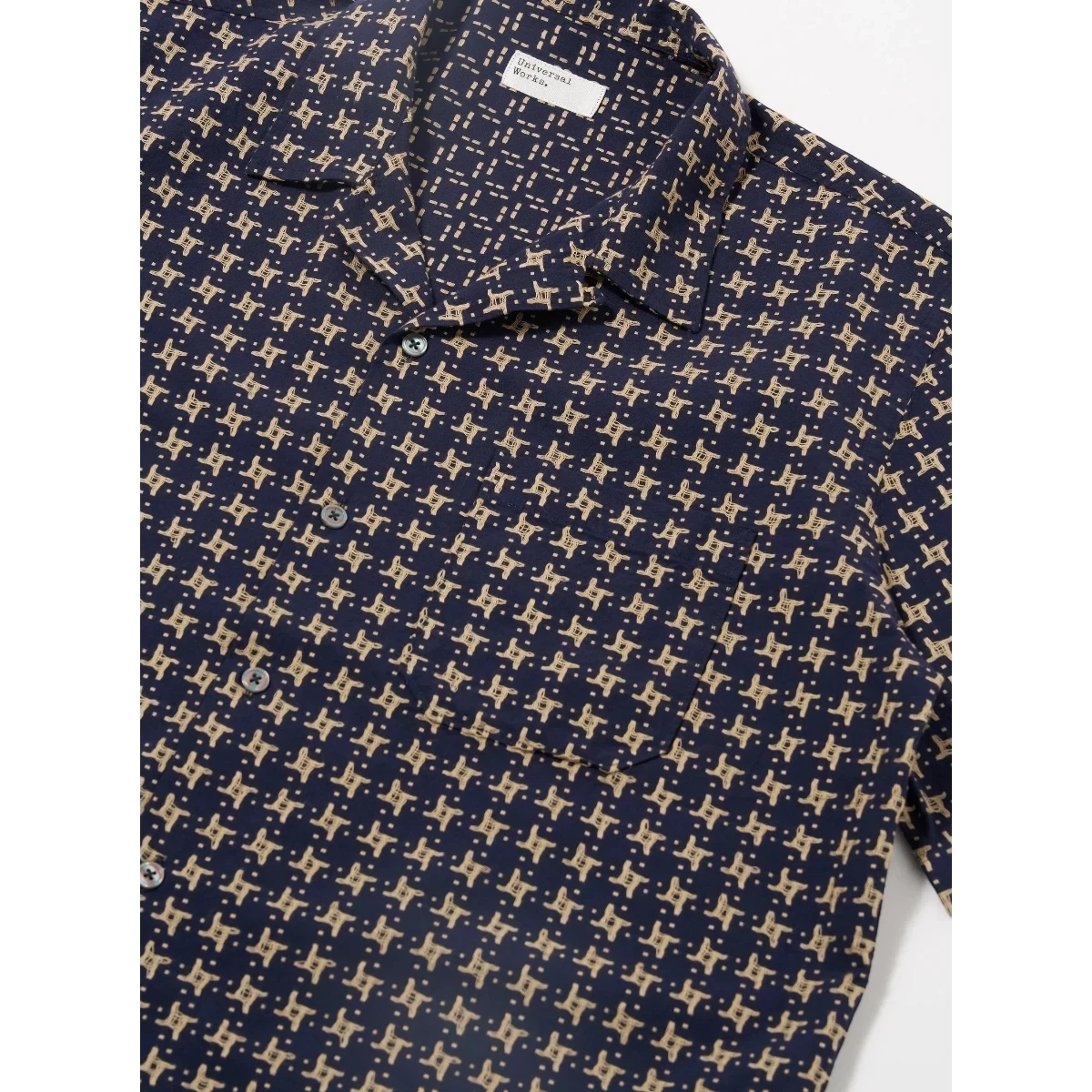 MILWORK Navy Sand Road Shirt with a repeating geometric pattern, short sleeves, and a single chest pocket. Features a camp collar with loop closure.