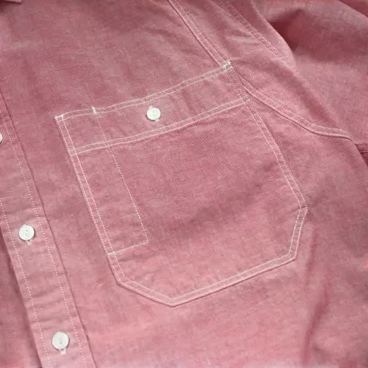 MILWORK red cotton chambray work shirt with dual chest pockets and white contrast stitching. Relaxed fit.