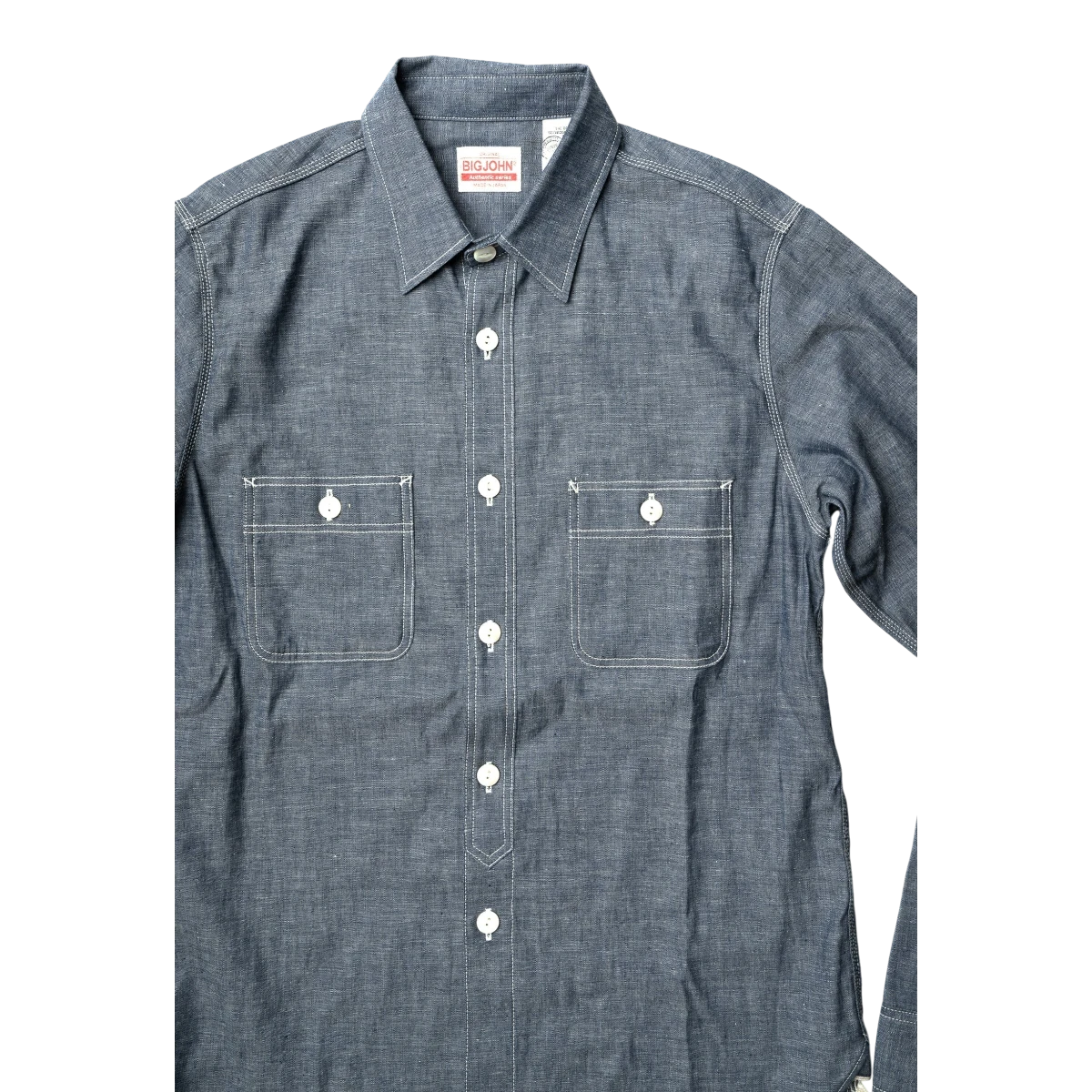 MILWORK Selvedge Chambray Work Shirt in indigo blue with white contrast stitching, two chest pockets, and shell buttons.