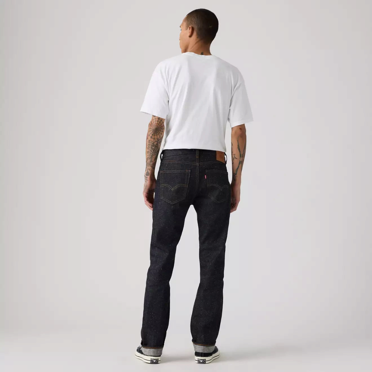 MILWORKS model wearing dark wash neppy rigid selvedge denim jeans with a straight leg fit from the back view