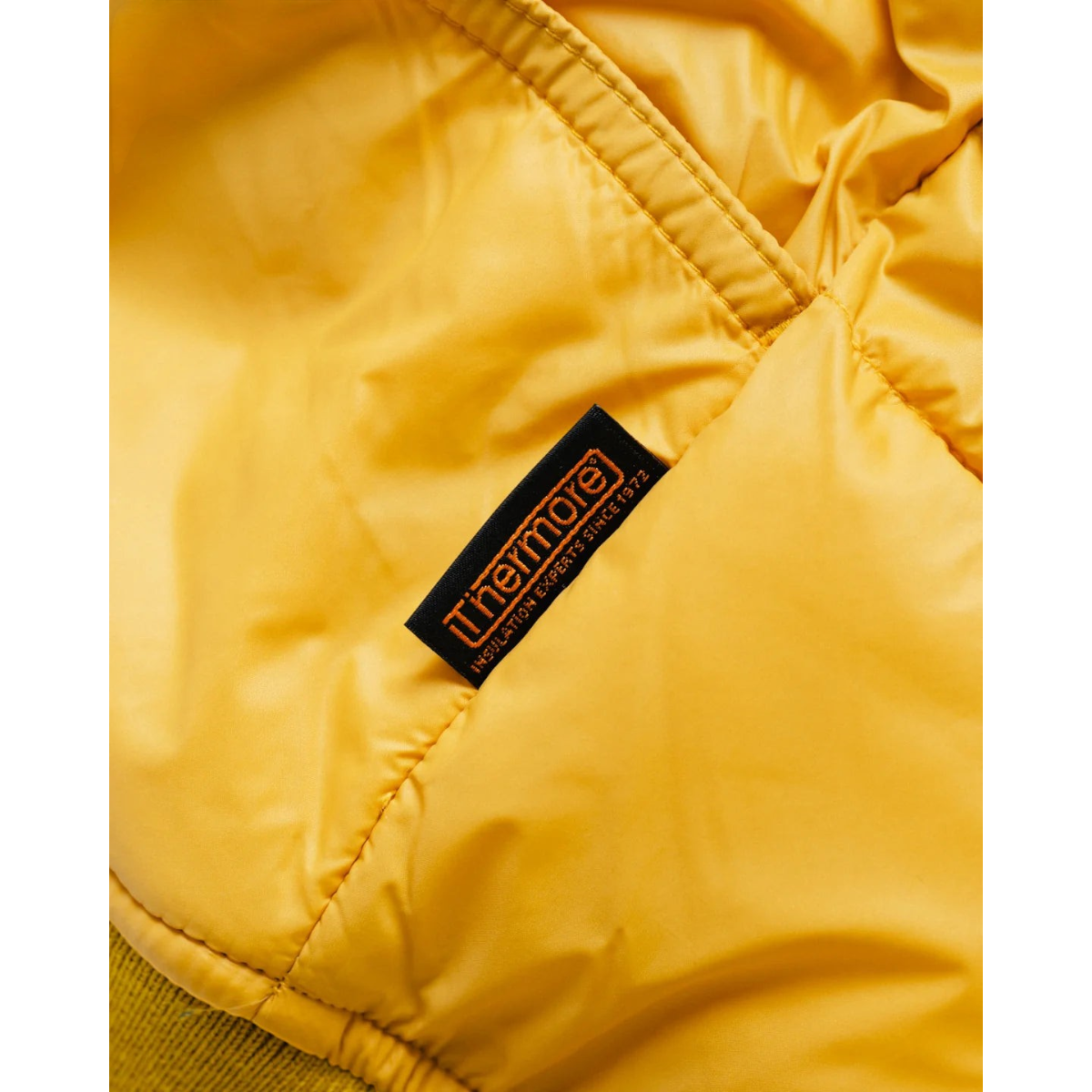 MILWORKS Alpine Jacket in mango nylon fabric featuring a black Thermore Ecodown insulation label detail