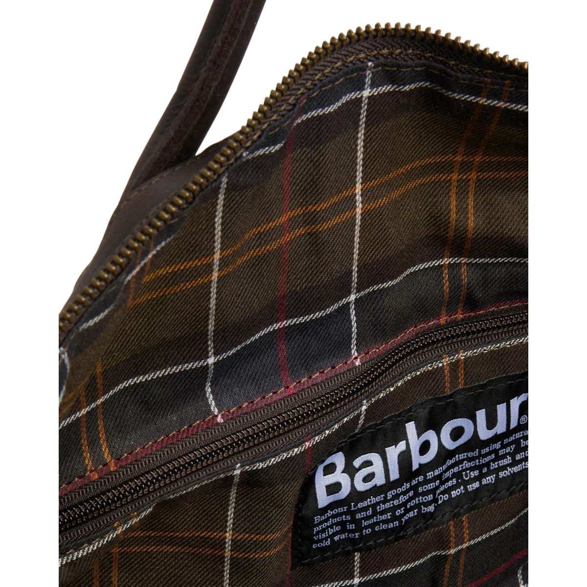 MILWORKS Barbour waxed holdall interior featuring classic tartan lining, brass zipper, and branded leather patch.