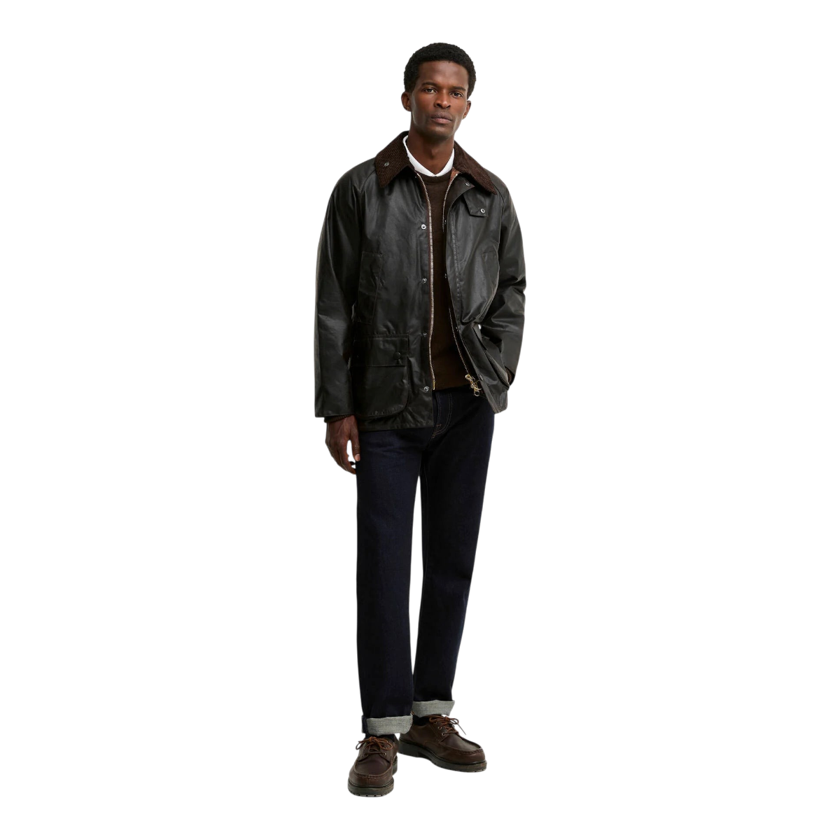A model wearing a MILWORKS rustic waxed cotton Bedale jacket with a corduroy collar, layered over a brown sweater.