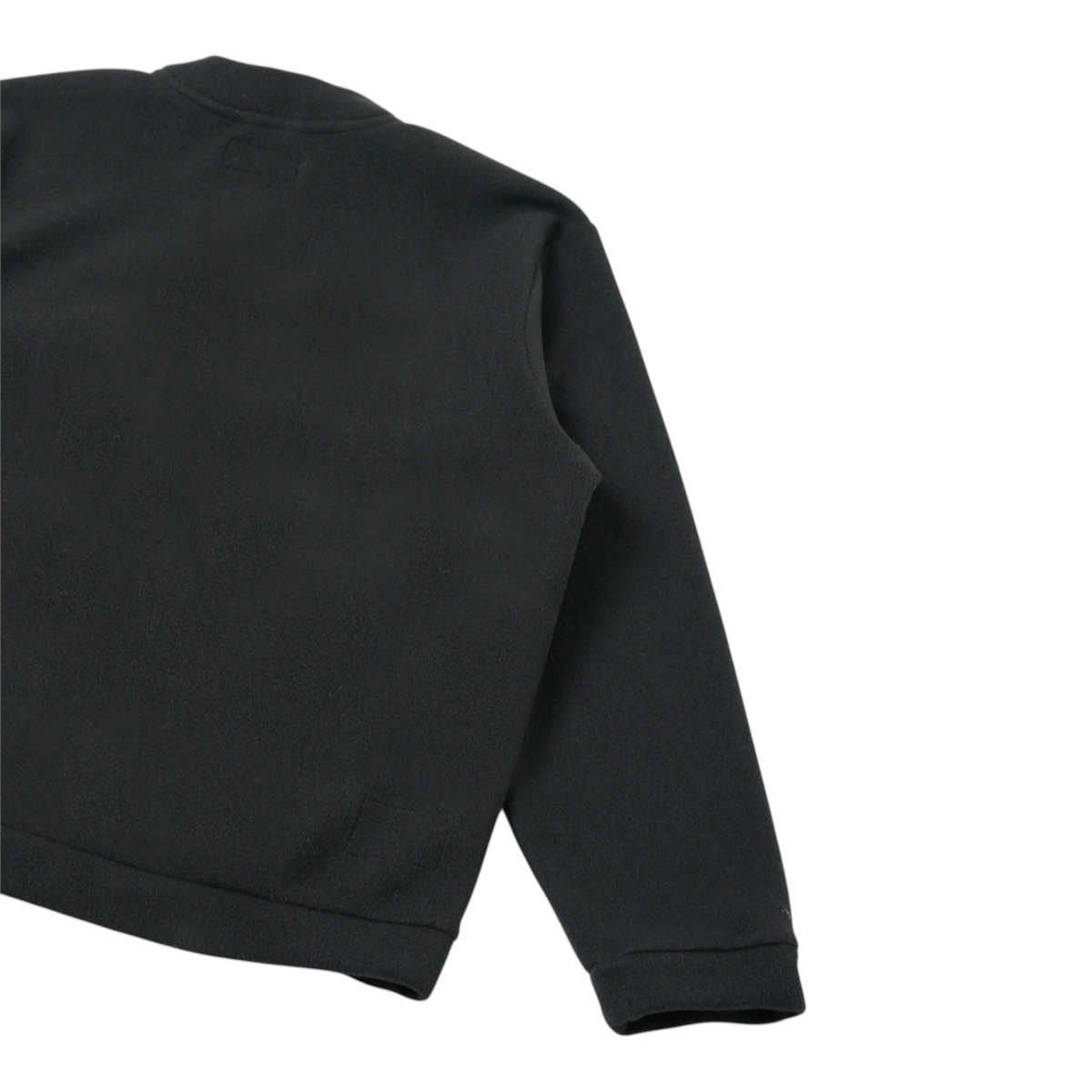 Back view of a MILWORKS Advance Cardigan in black fleece with a boxy fit, elasticated hem, and long sleeves.