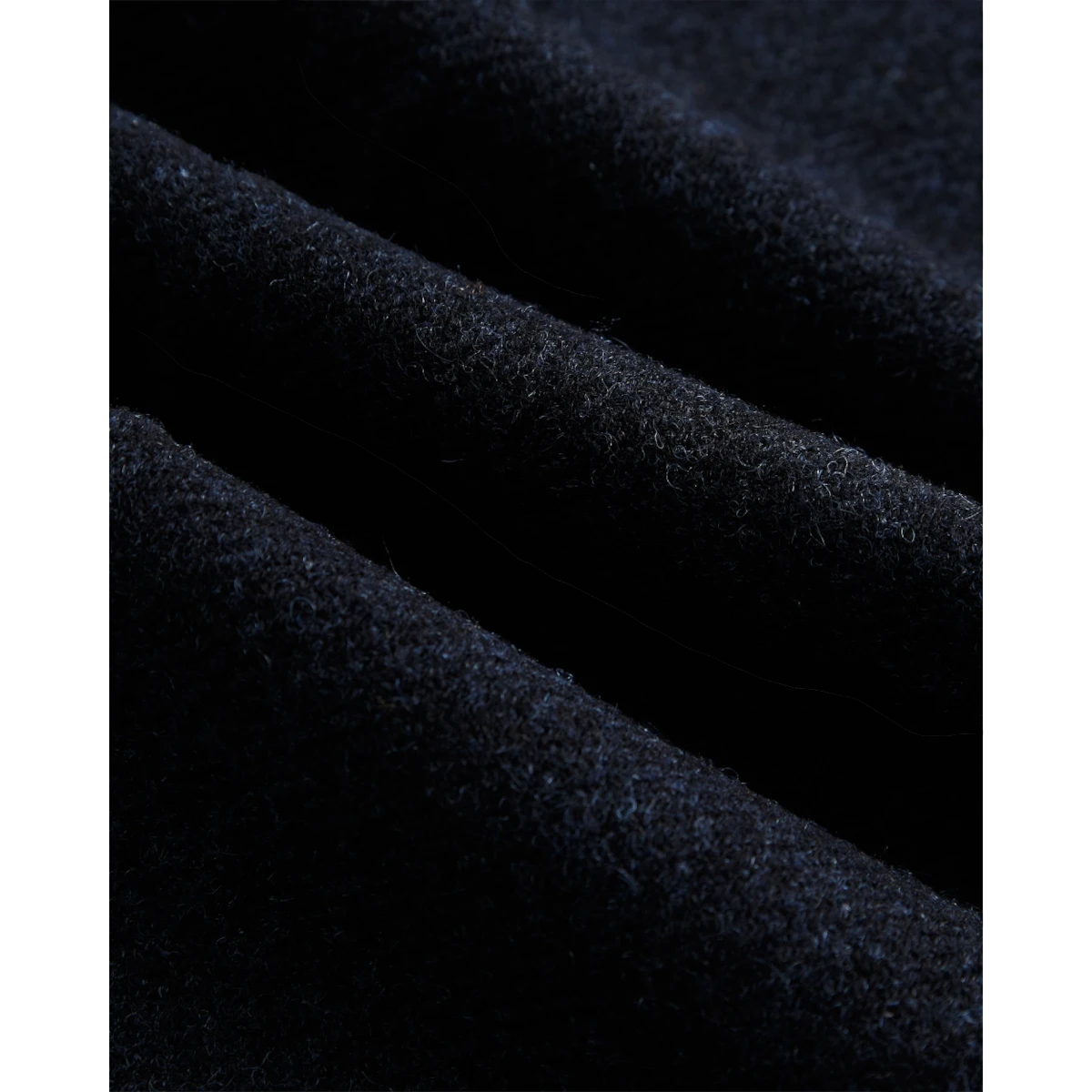Close-up of deep blue 100% virgin wool fabric from MILWORKS single pleat trousers showing soft texture and folds