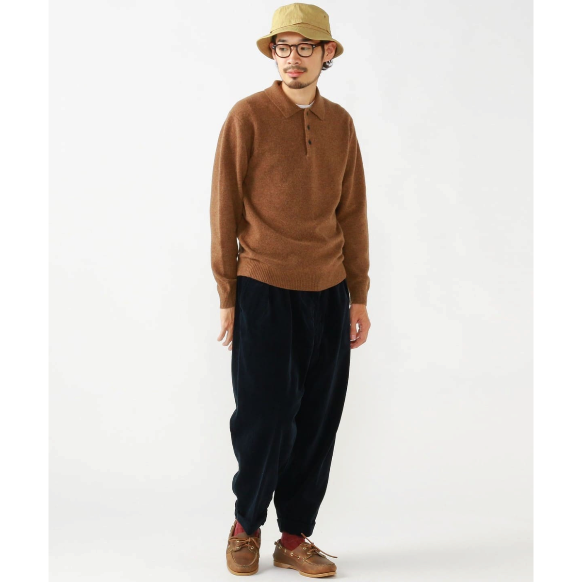 MILWORKS model wearing a brown 9-gauge wool knit polo shirt with a three-button collar, paired with dark trousers.
