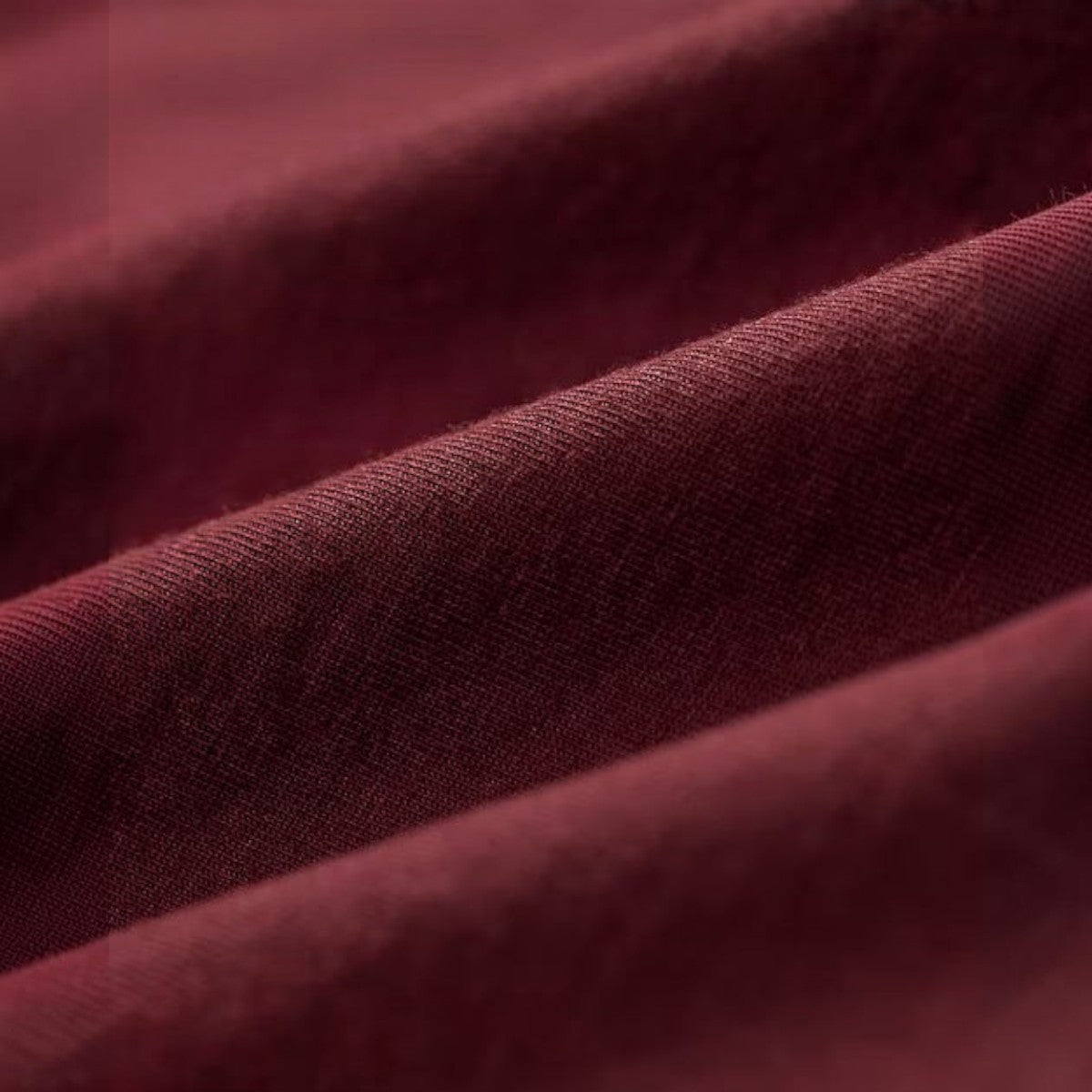 Close-up of MILWORKS vintage burgundy garment-dyed cotton jersey fabric with a soft, textured finish.