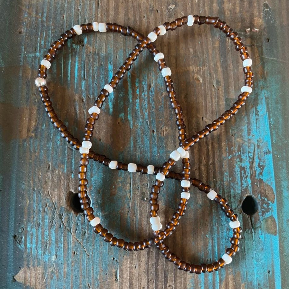 MILWORKS chocolate glass trade bead necklace with white seed bead accents and a sterling silver crimp closure.