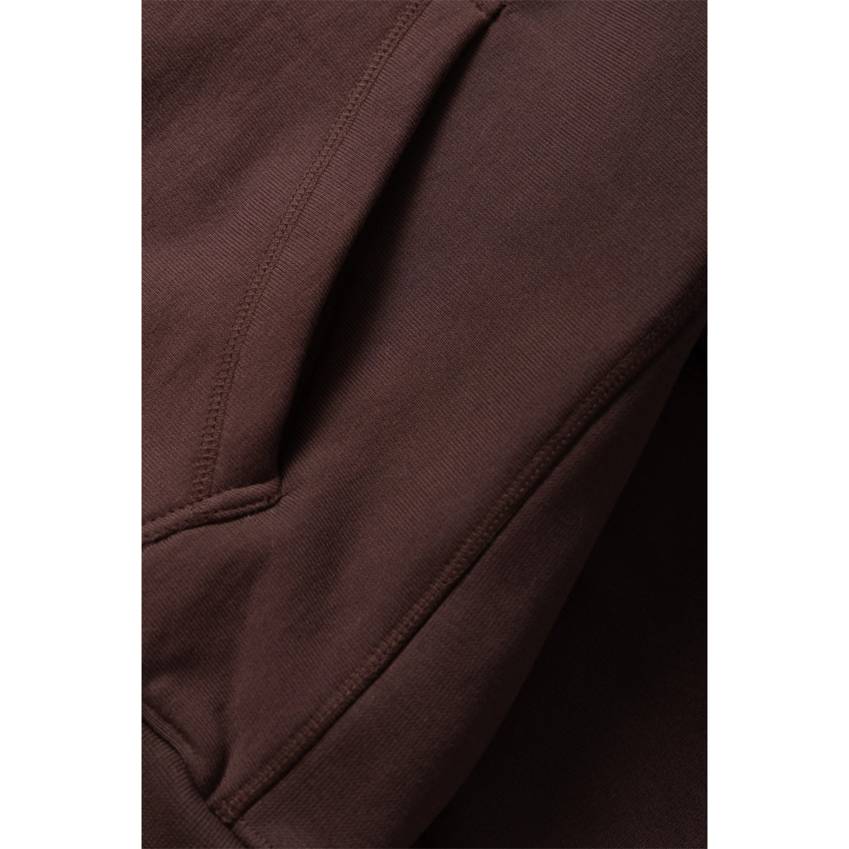 Close-up of MILWORKS coffee brown 16oz organic cotton heavyweight hoodie showing durable stitching and side ribbing.