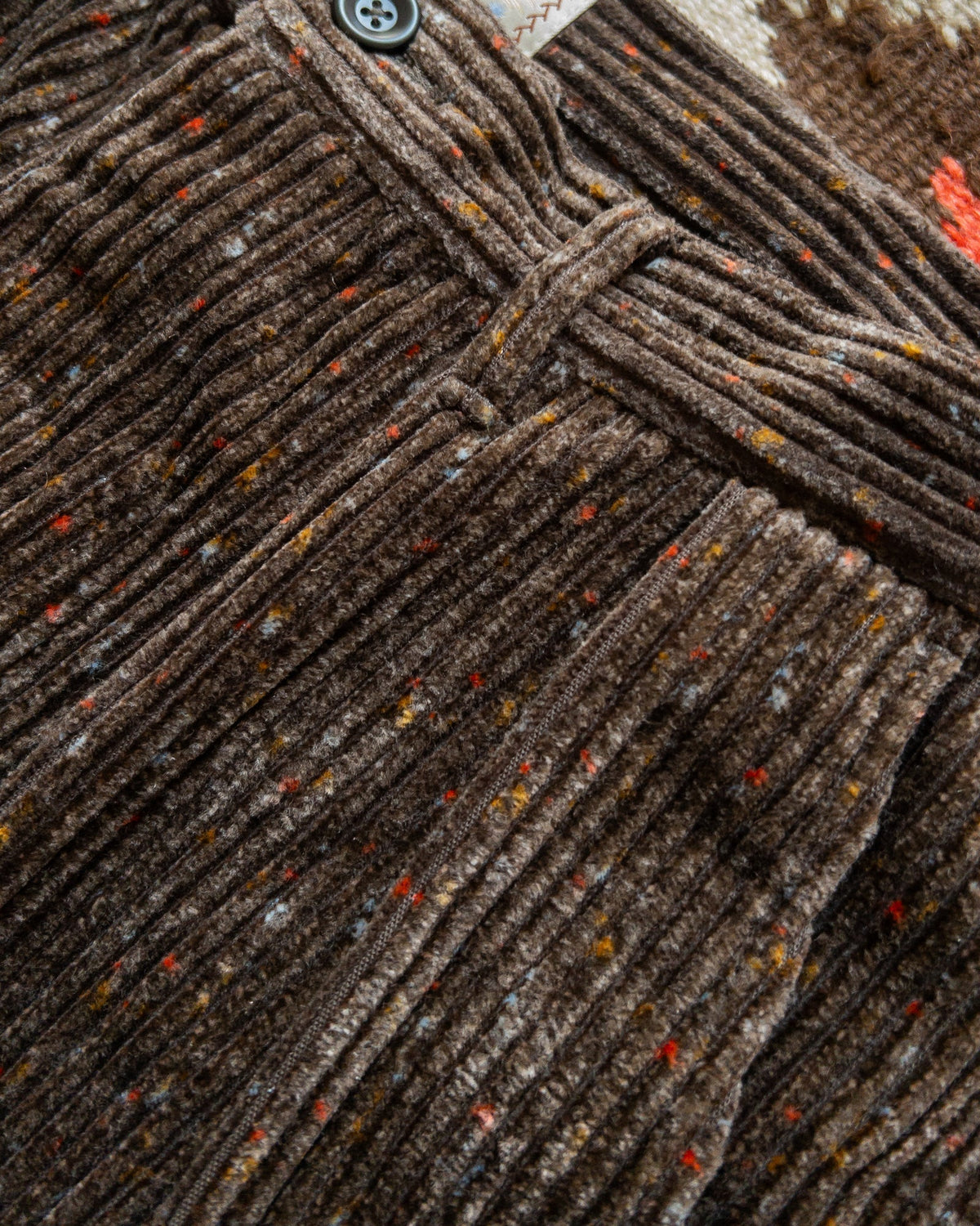 MILWORKS Donegal corduroy pleated chinos in rustic brown with a textured wide wale fabric and colorful flecks.