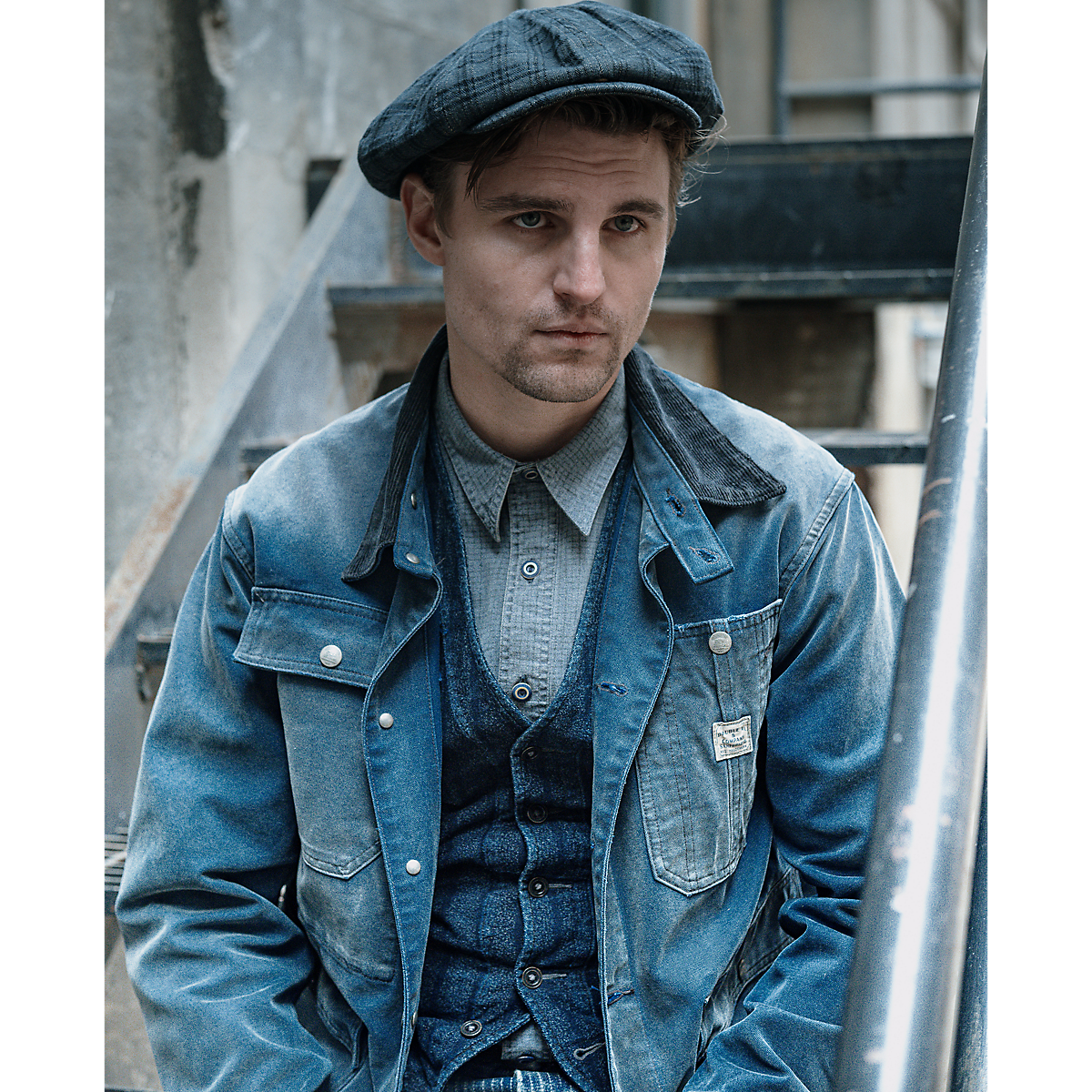 MILWORKS faded navy cotton canvas engineer jacket with a corduroy collar worn by a man in a vintage-inspired outfit.