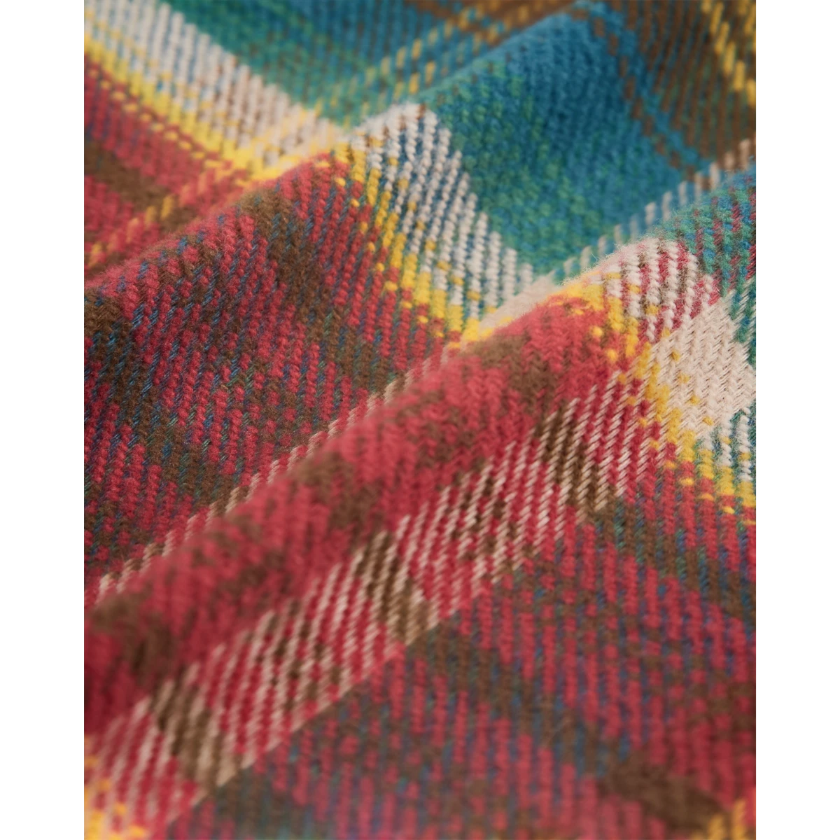 Close-up of MILWORKS Fasema plaid flannel shirt fabric featuring a soft multi-colored cotton weave in red and teal.