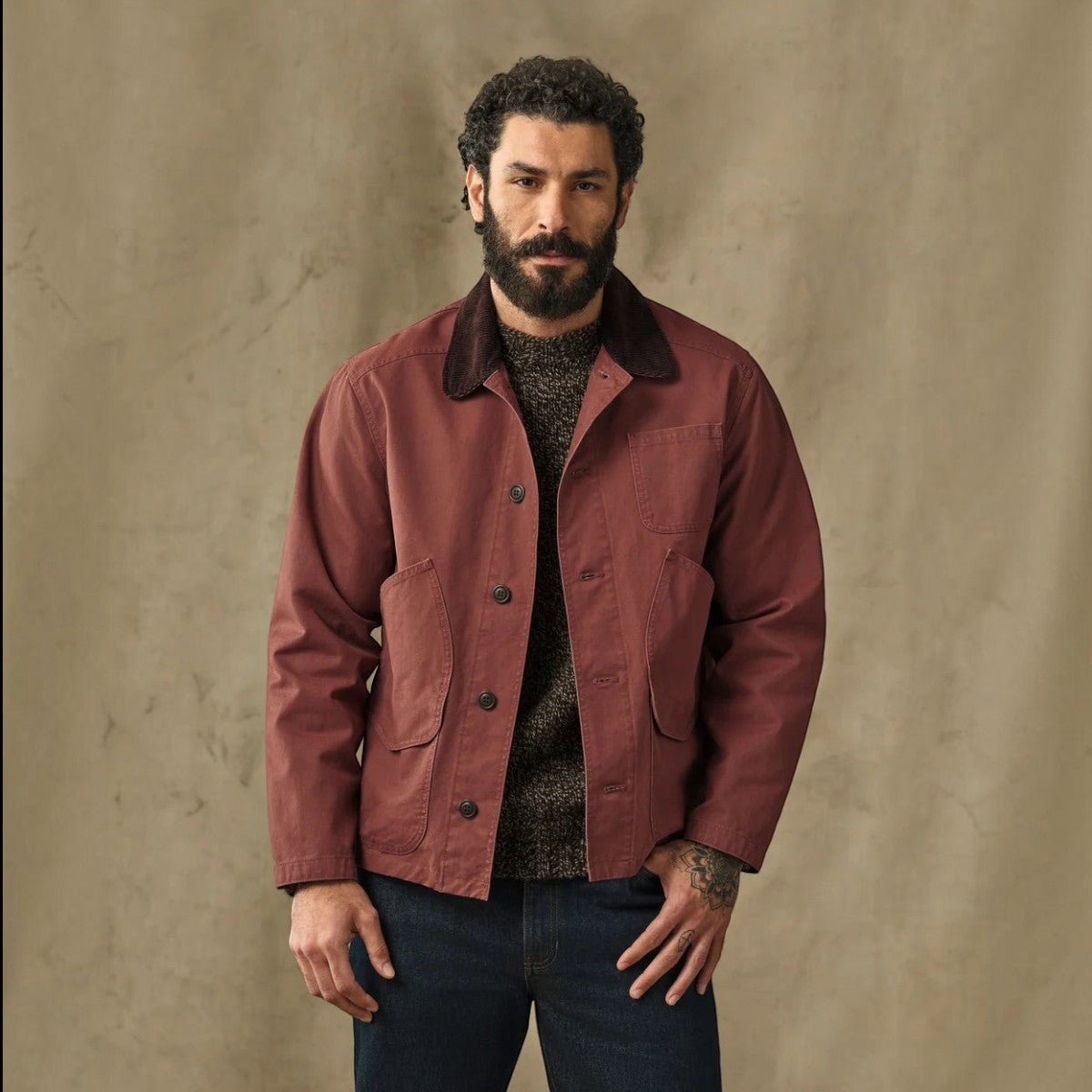 MILWORKS Filson Canvas Outfitter Jacket in Sequoia red with a corduroy-lined collar worn by a bearded model.