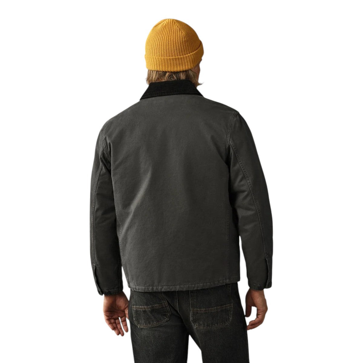 Back view of a man wearing a MILWORKS Filson insulated peat canvas jacket with a corduroy collar and yellow beanie.