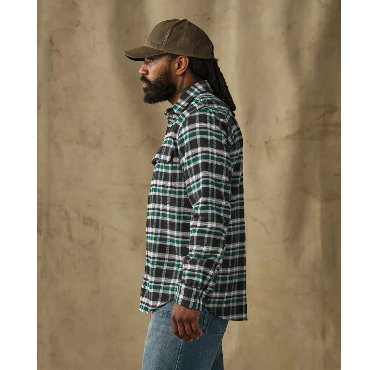 MILWORKS Filson vintage flannel work shirt in black and green plaid worn by a man in profile view.