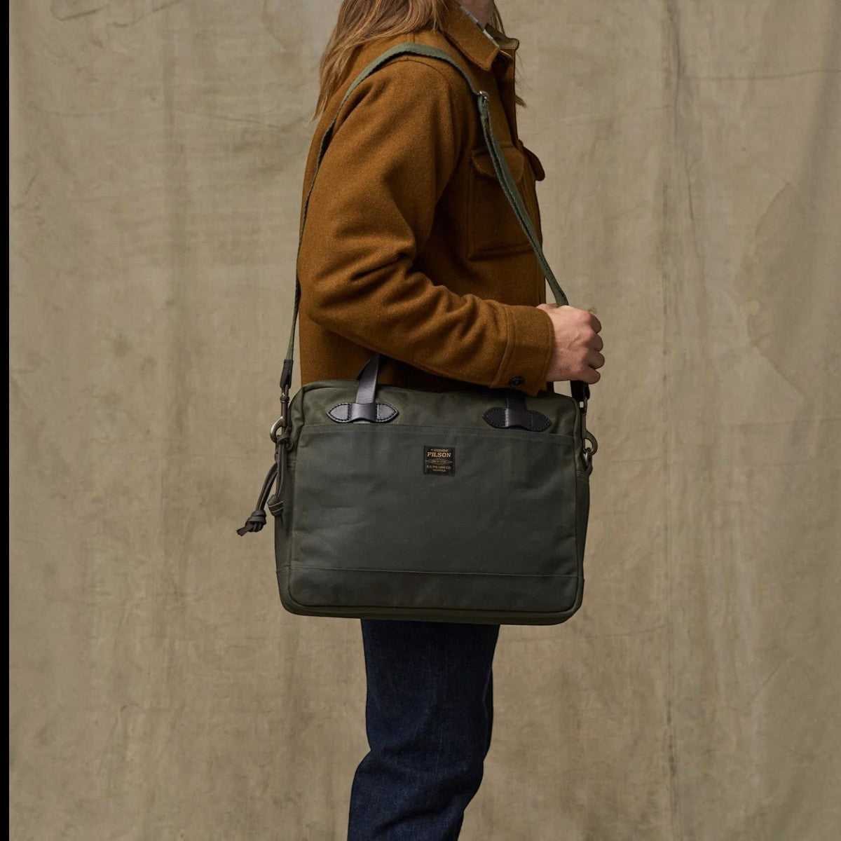 MILWORKS Filson Tin Cloth Compact Briefcase in Otter Green waxed cotton with leather handles worn over the shoulder
