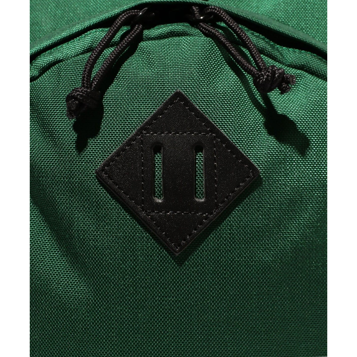 MILWORKS green daypack featuring a black leather lash tab detail with drawstring zipper pulls