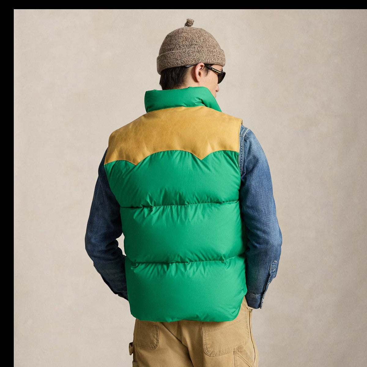 MILWORKS green ripstop down vest with tan leather Western yoke worn by a man in a denim shirt and beanie