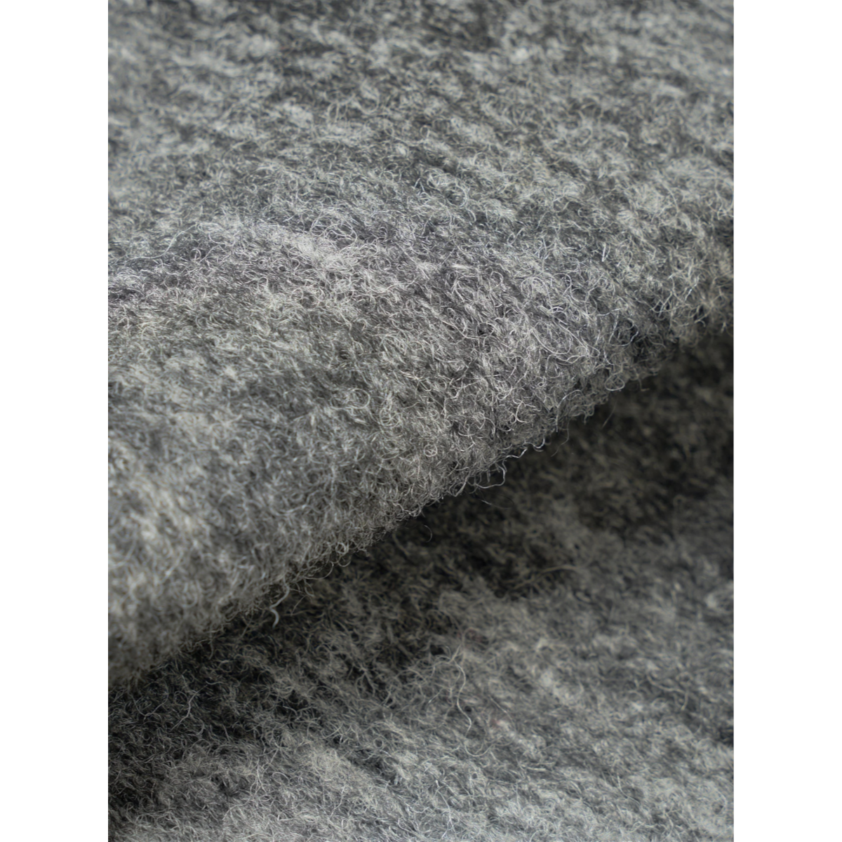 Close-up of the grey marl wool mix knit fabric texture from the MILWORKS Advance cardigan.