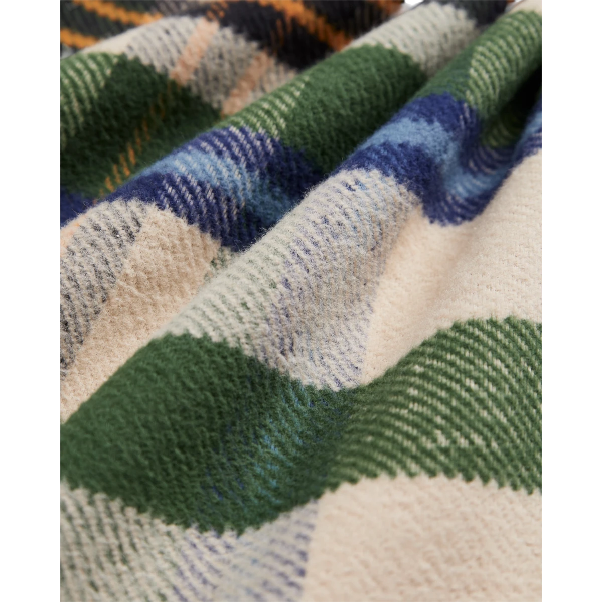 Close-up of MILWORKS Harbor Plaid Flannel Shirt fabric featuring soft green, blue, and cream cotton plaid pattern