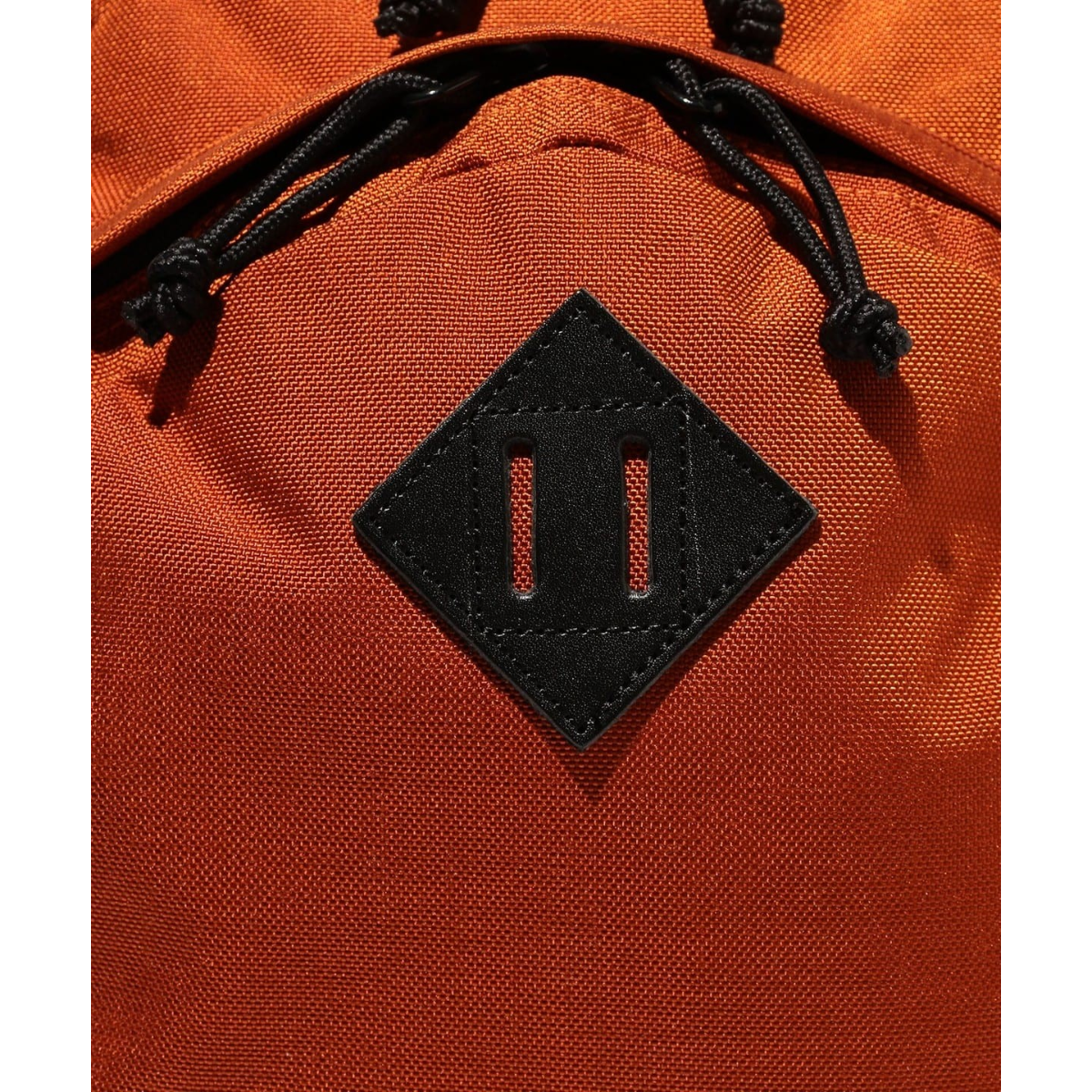 MILWORKS orange day pack featuring a black leather lash tab detail on durable fabric