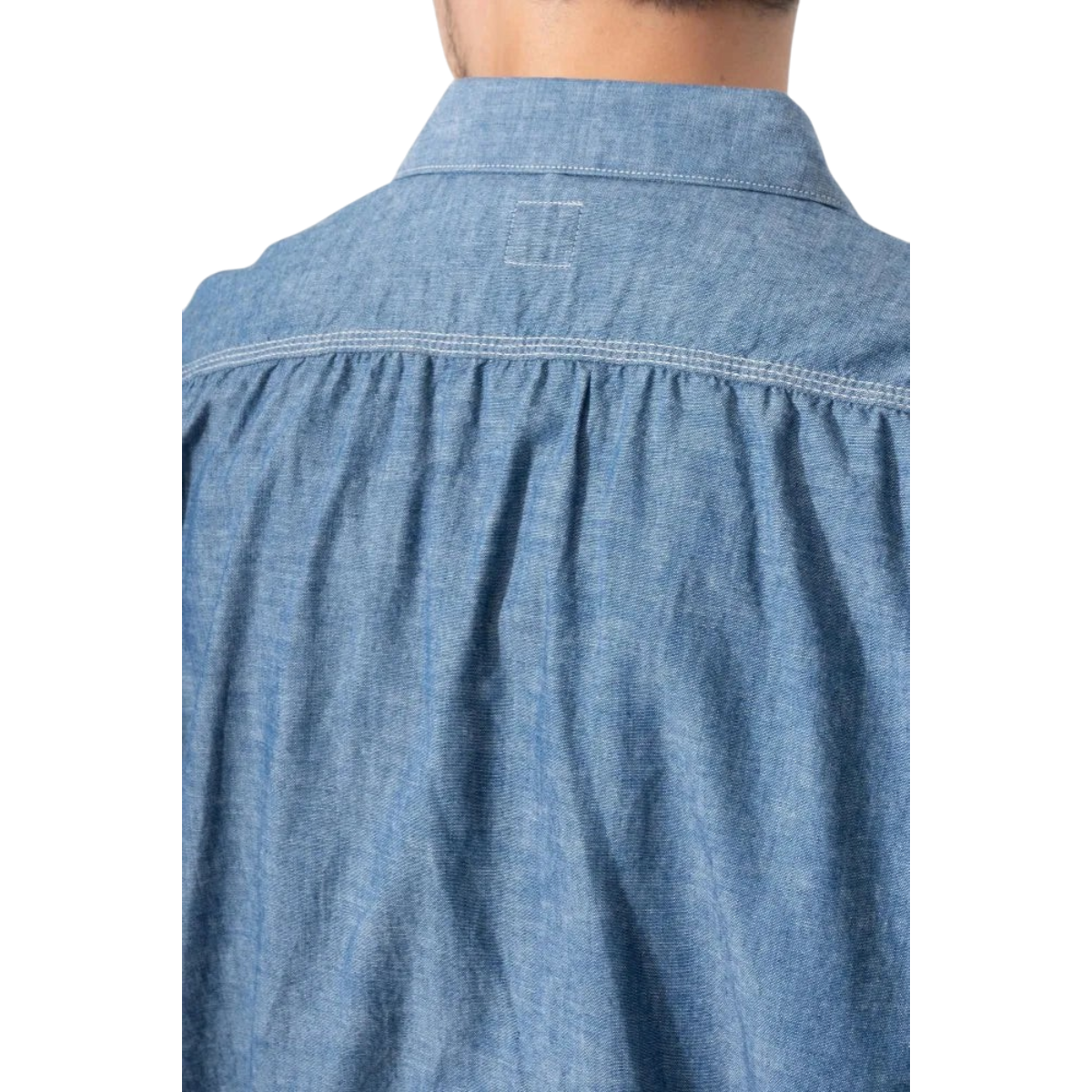 MILWORKS Ordinary Fits indigo chambray work shirt showing the back yoke with gathered detailing and white stitching.
