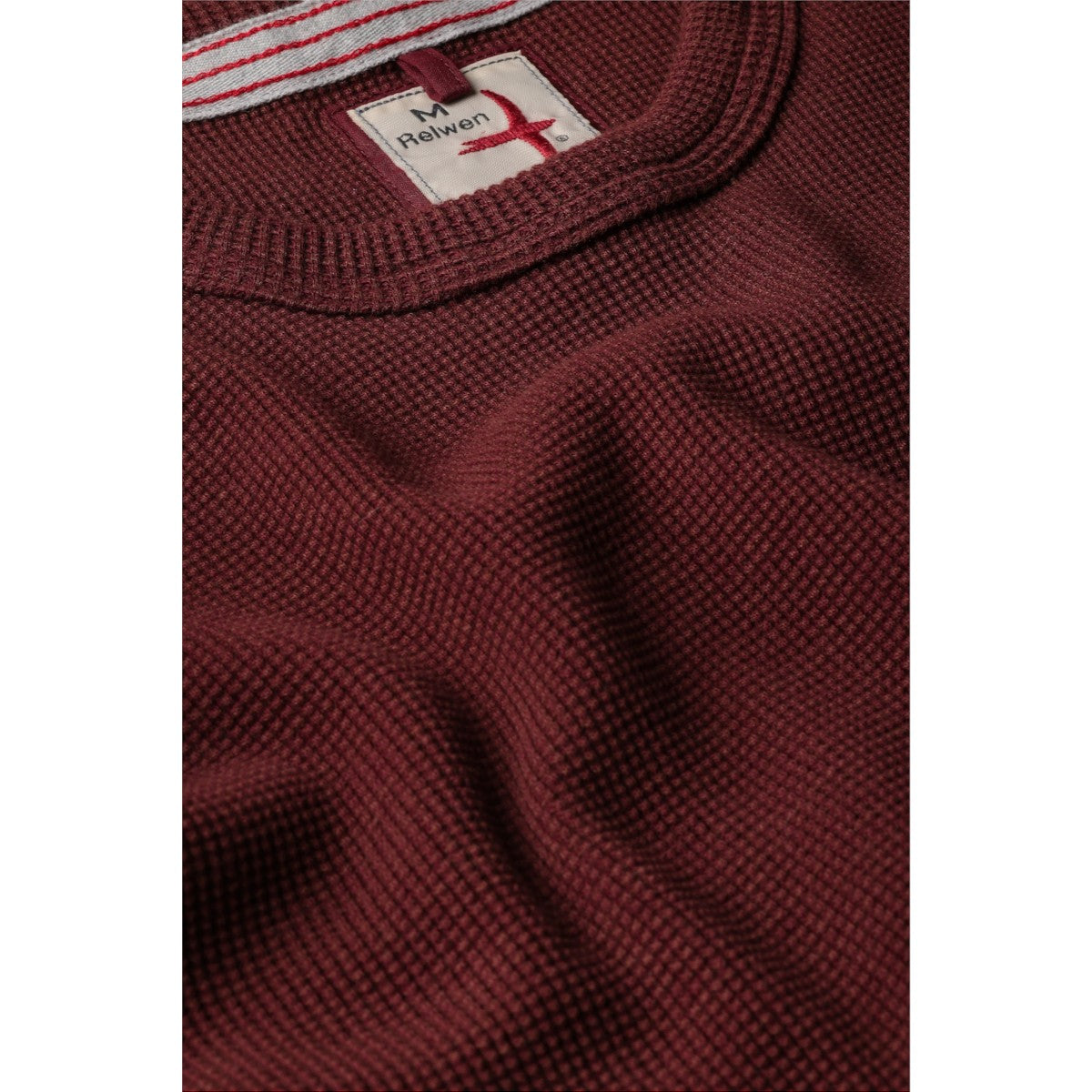 Close-up of a MILWORKS Relwen Bi Waffle Crew sweater in burgundy, featuring a textured waffle knit and ribbed collar.