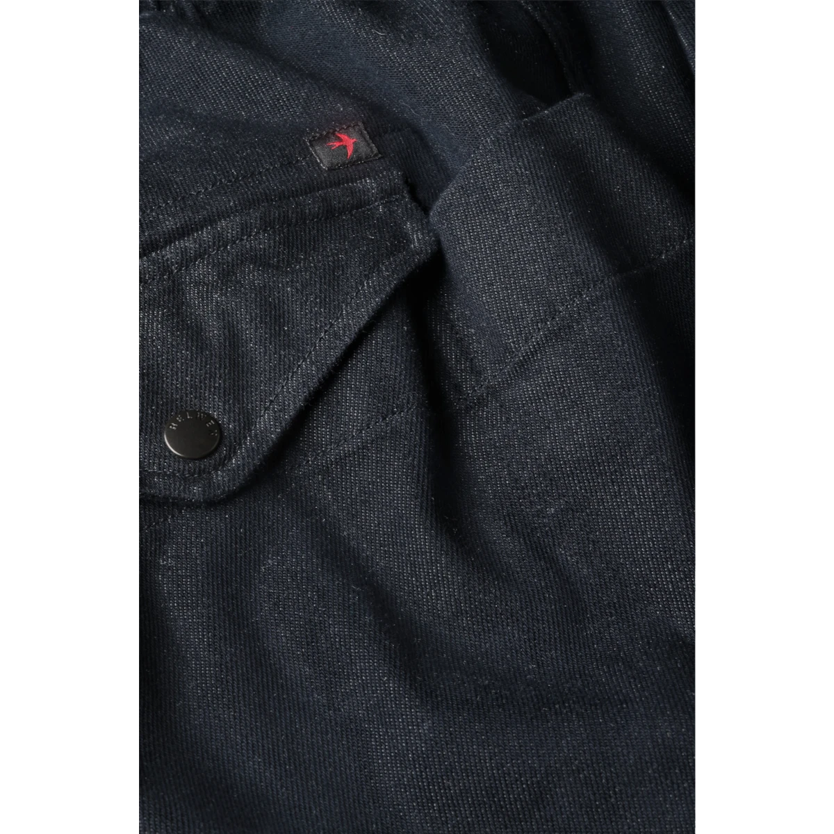 MILWORKS Relwen dark indigo utility pant featuring a drawstring waist and a small red embroidered bird logo detail.
