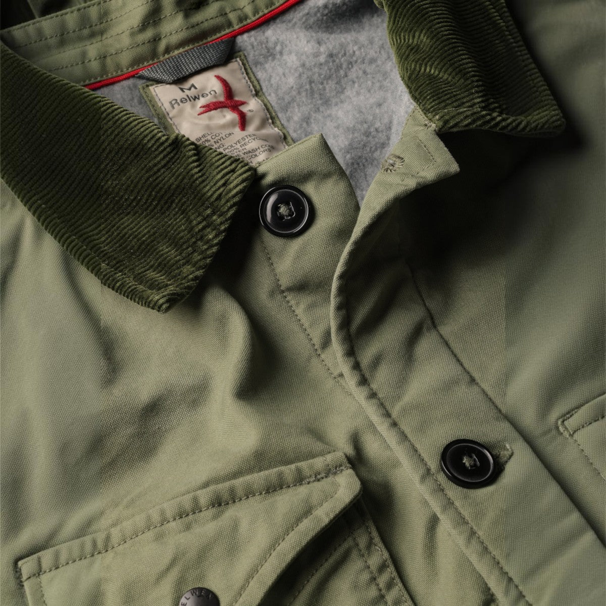 MILWORKS Relwen pile lined chore coat in palm green with a dark green corduroy collar and button-up front detail.