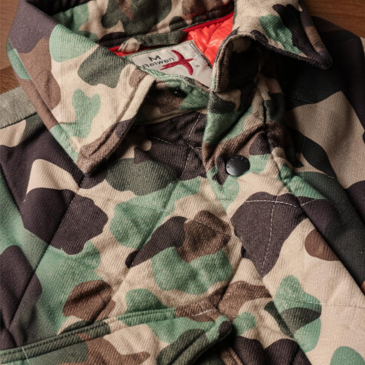 MILWORKS Relwen quilted flannel shirt jacket in duck camo print with a bright orange interior lining