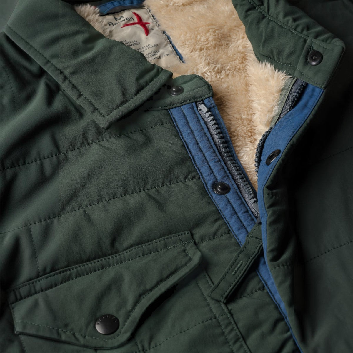 MILWORKS Relwen quilted dark forest green jacket with a soft cream-colored fleece lining and snap button closure.
