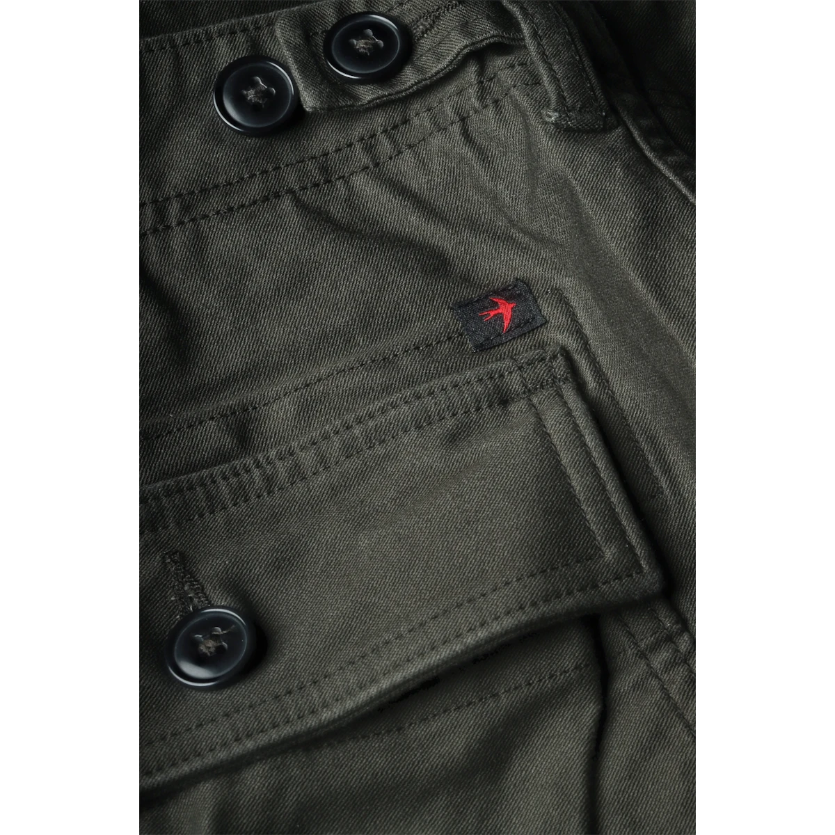MILWORKS Relwen Supply Pant in dark smoke featuring a utility pocket with button closures and a small bird logo patch.