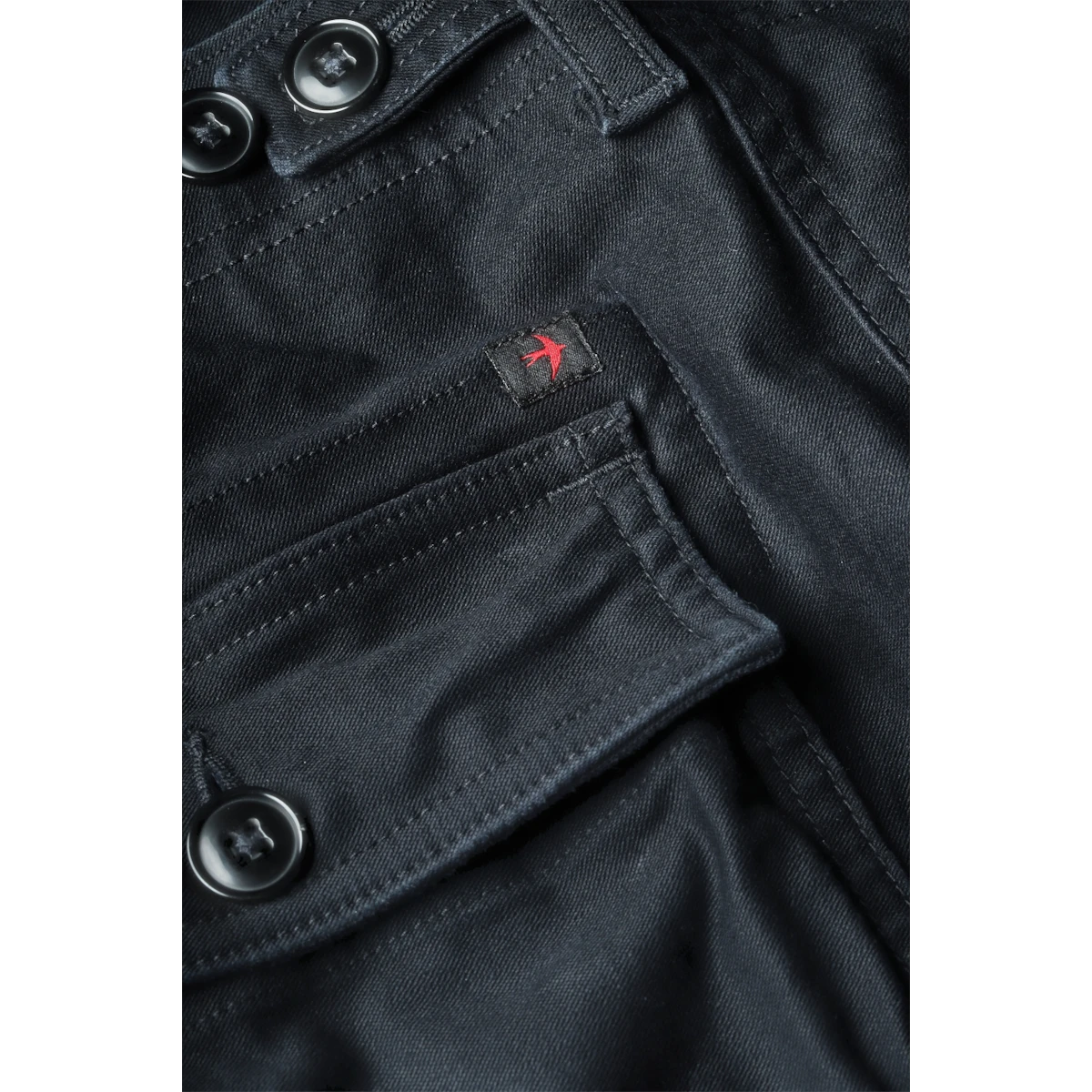 MILWORKS Relwen Supply Pant in dark navy featuring a buttoned cargo pocket and small red bird logo embroidery