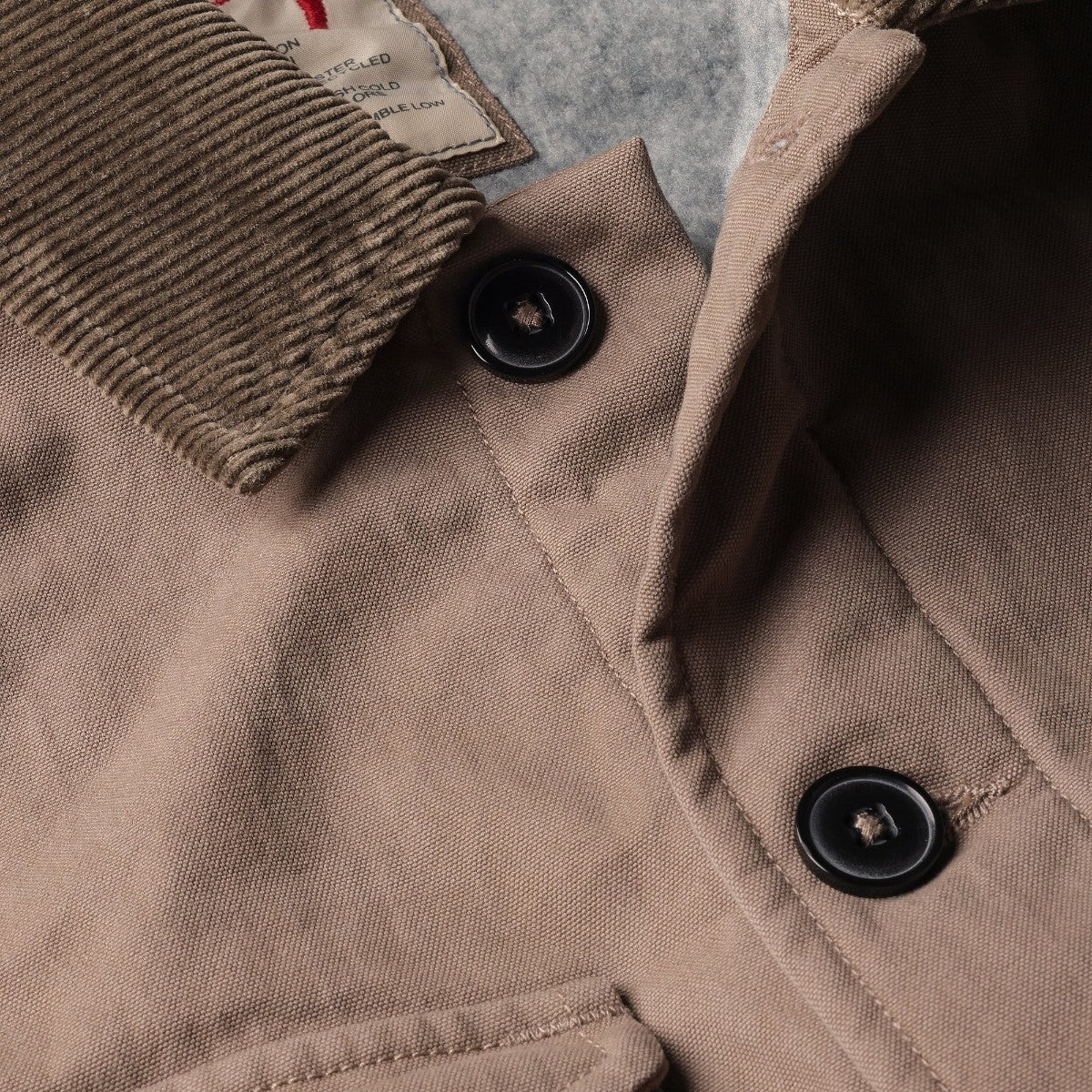 MILWORKS Relwen tobacco chore coat featuring a corduroy collar and soft grey pile lining with black button details.