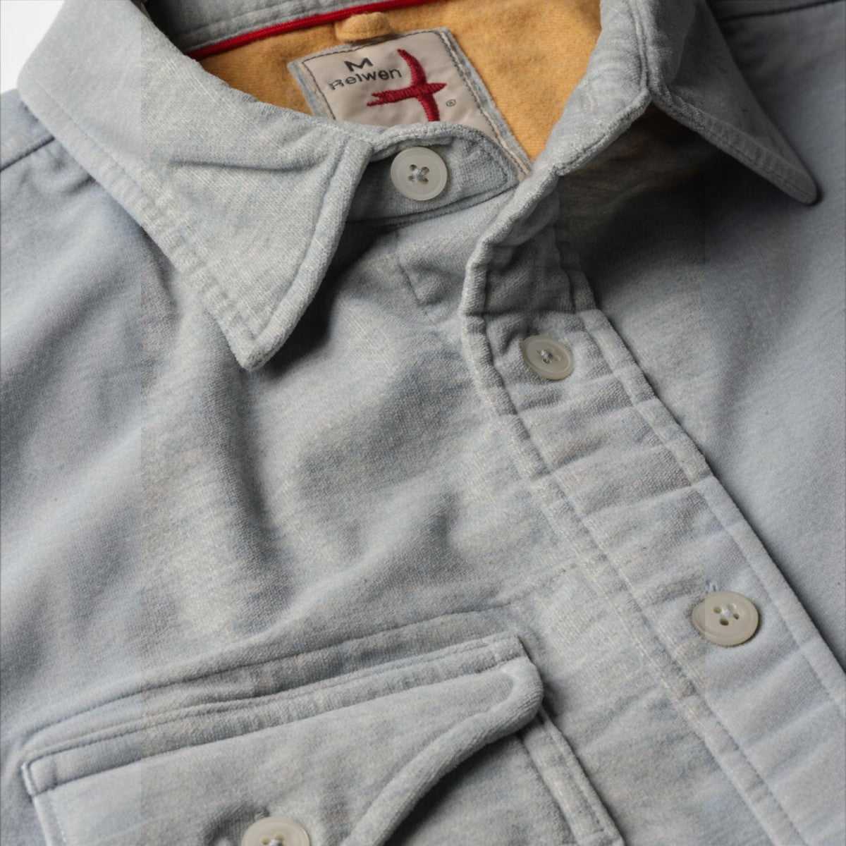 MILWORKS Relwen Utility Workshirt in cloud blue sueded fabric with a soft yellow interior lining and button closure.