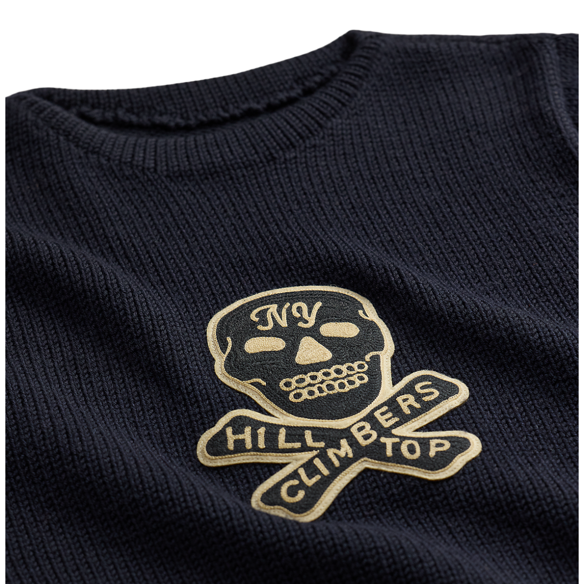 MILWORKS RRL dark navy long sleeve pullover sweater with a gold embroidered skull and crossbones patch