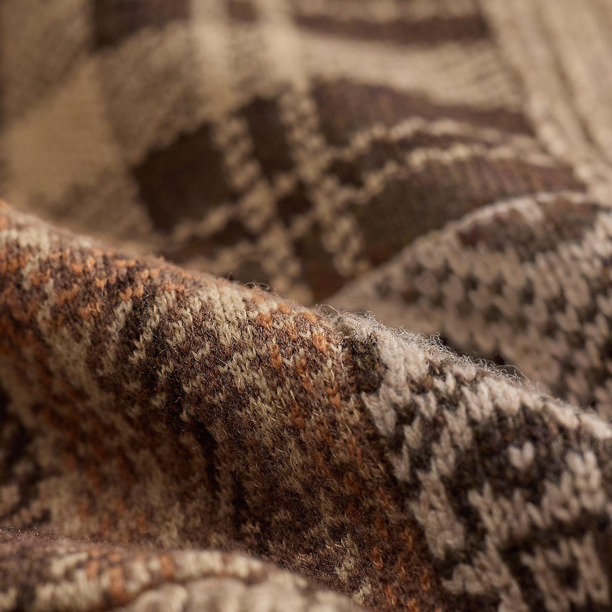 Close-up of a MILWORKS RRL wool blend sweater featuring a brown and cream plaid pattern with soft textured fabric.