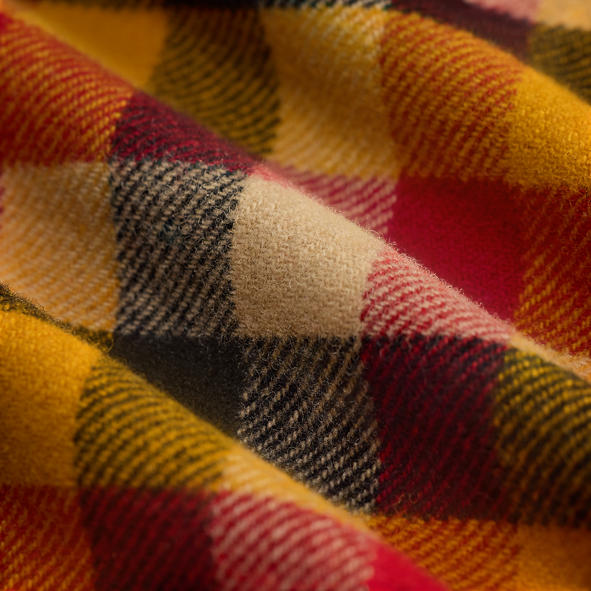Close-up of a MILWORKS RRL wool woven shirt featuring a vibrant yellow, red, and black plaid check pattern.