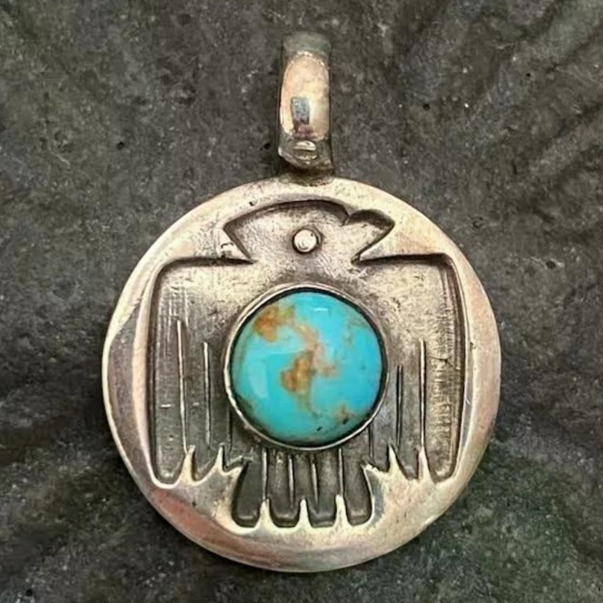 MILWORKS turquoise thunderbird charm featuring a round silver pendant with a stamped design and central stone