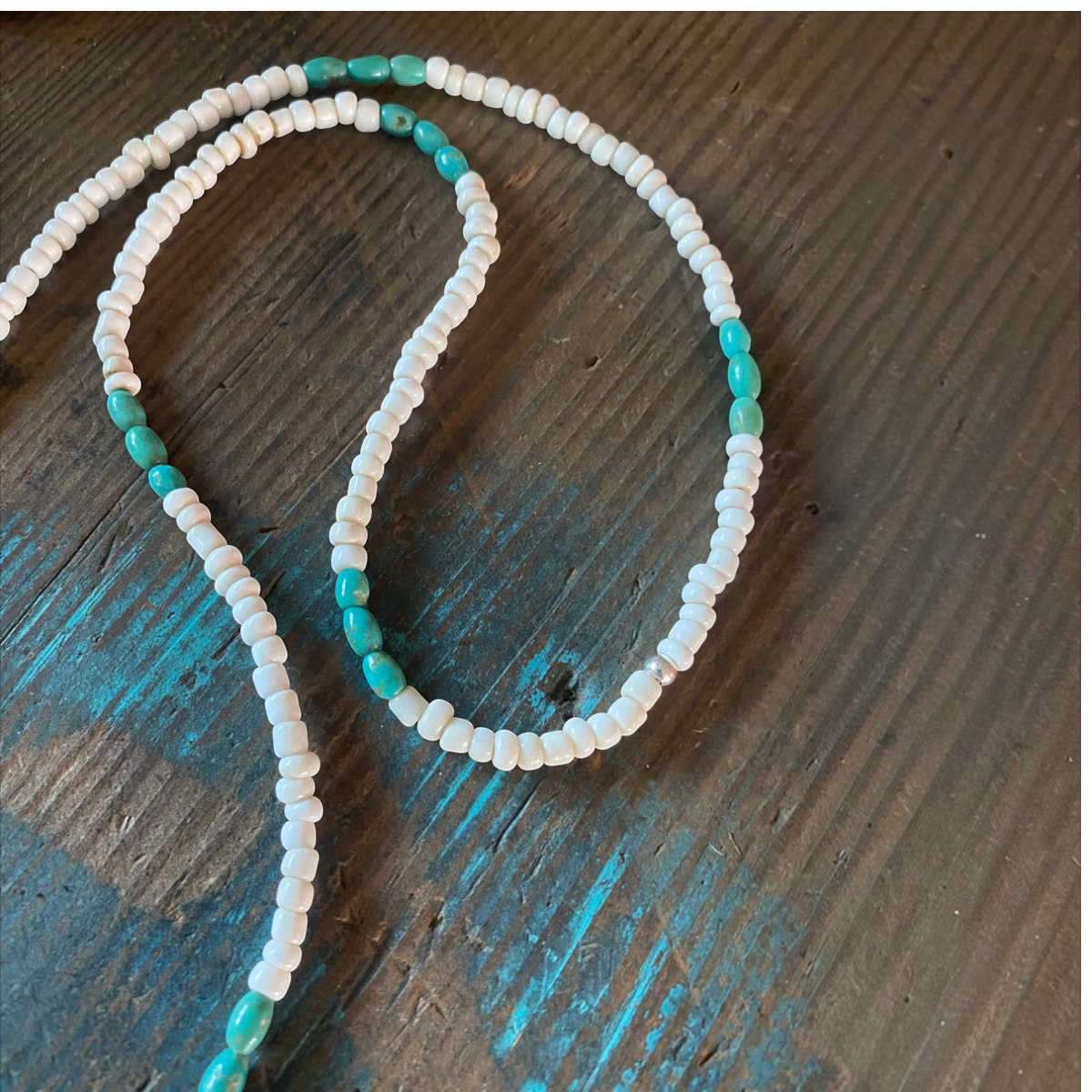 MILWORKS 26-inch necklace featuring genuine turquoise and white glass seed beads on a rustic wooden surface.