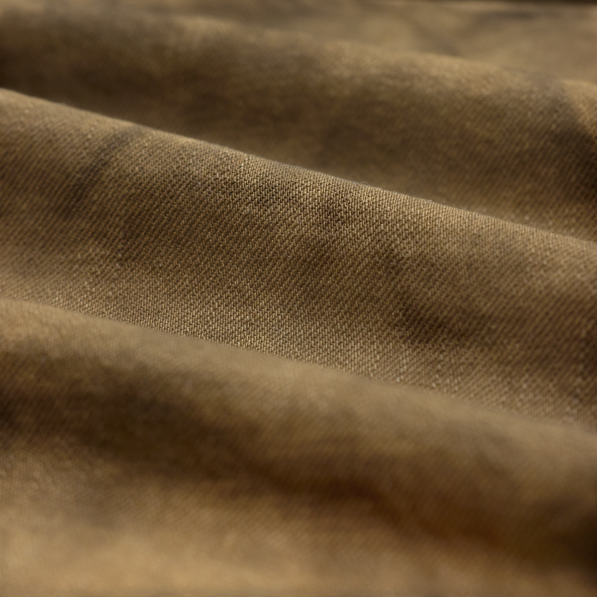 Close-up of MILWORKS RRL vintage brown denim fabric with a textured weave and soft folds.